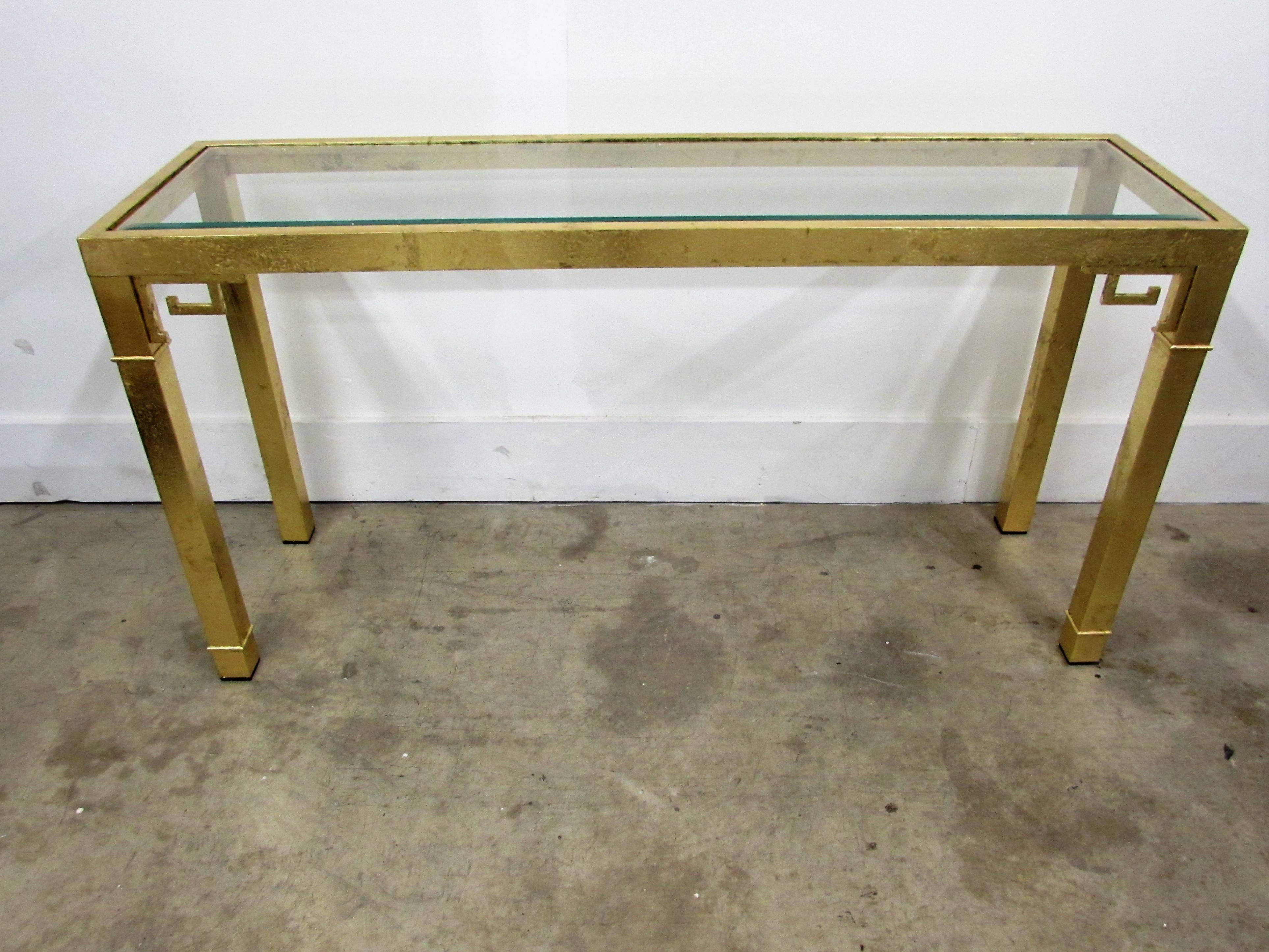 Rectangle console table my Mastercraft in solid brass under hand-applied gold leaf with a clear bevelled inset flush glass top and Greek key embellishments.
Marked Made in Italy.