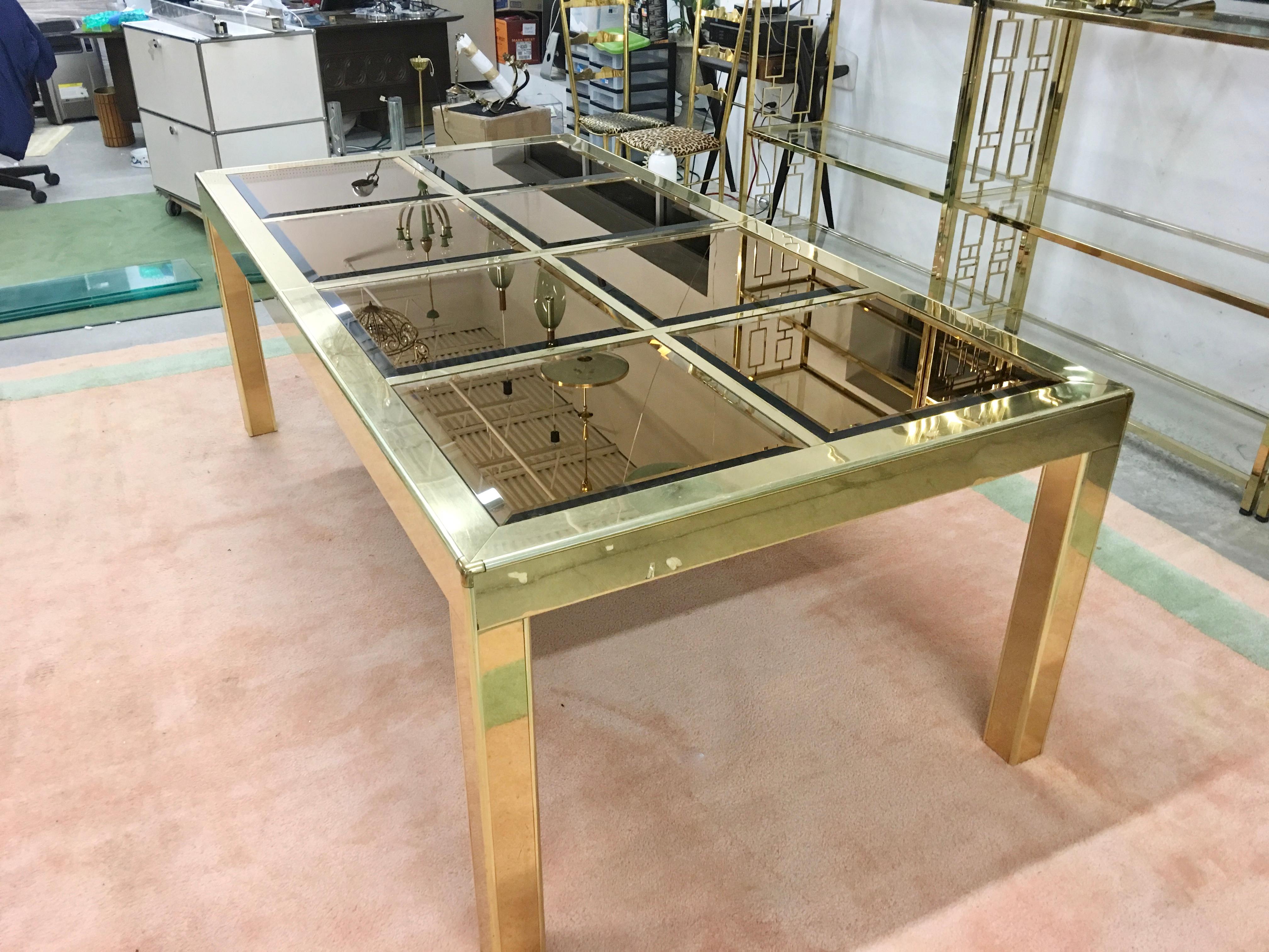Brass framed parsons shape dining table by Mastercraft of Grand Rapids. The top of the table is an open grid into which inserts the 18 inch by 18 inch square shaped mirror panels which are beveled and are tinted a metallic bronze giving this table a
