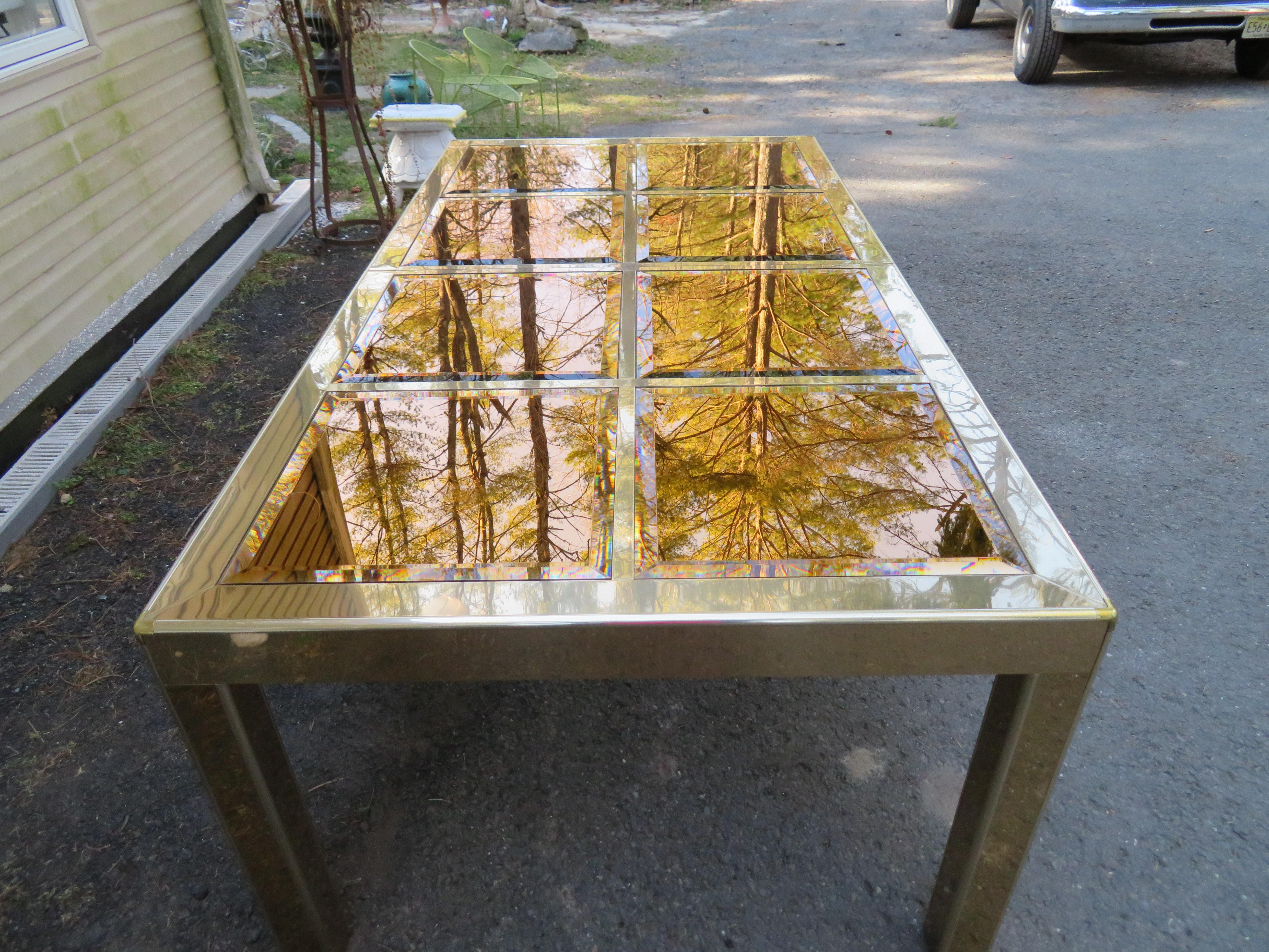 Brass framed parsons shape dining table by Mastercraft of Grand Rapids. The top of the table is an open grid into which inserts the 18 inch by 18 inch square shaped mirror panels which are beveled and are tinted a metallic bronze giving this table a