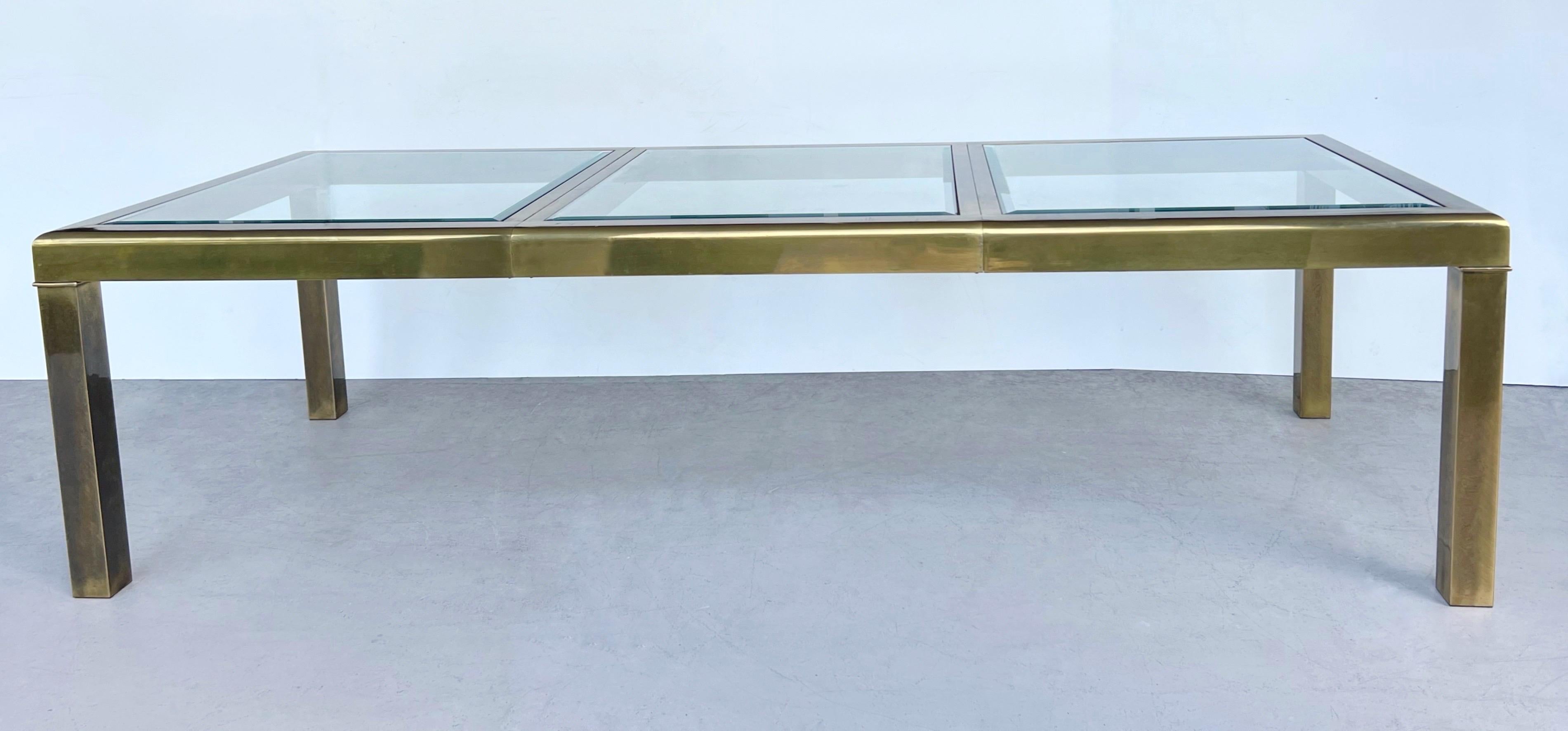 A classic Mastercraft dining table. Handsome and substantial brass frame. Angular design with subtle radial edge along the perimeter of the top. The inset glass tops are beveled and removable. 