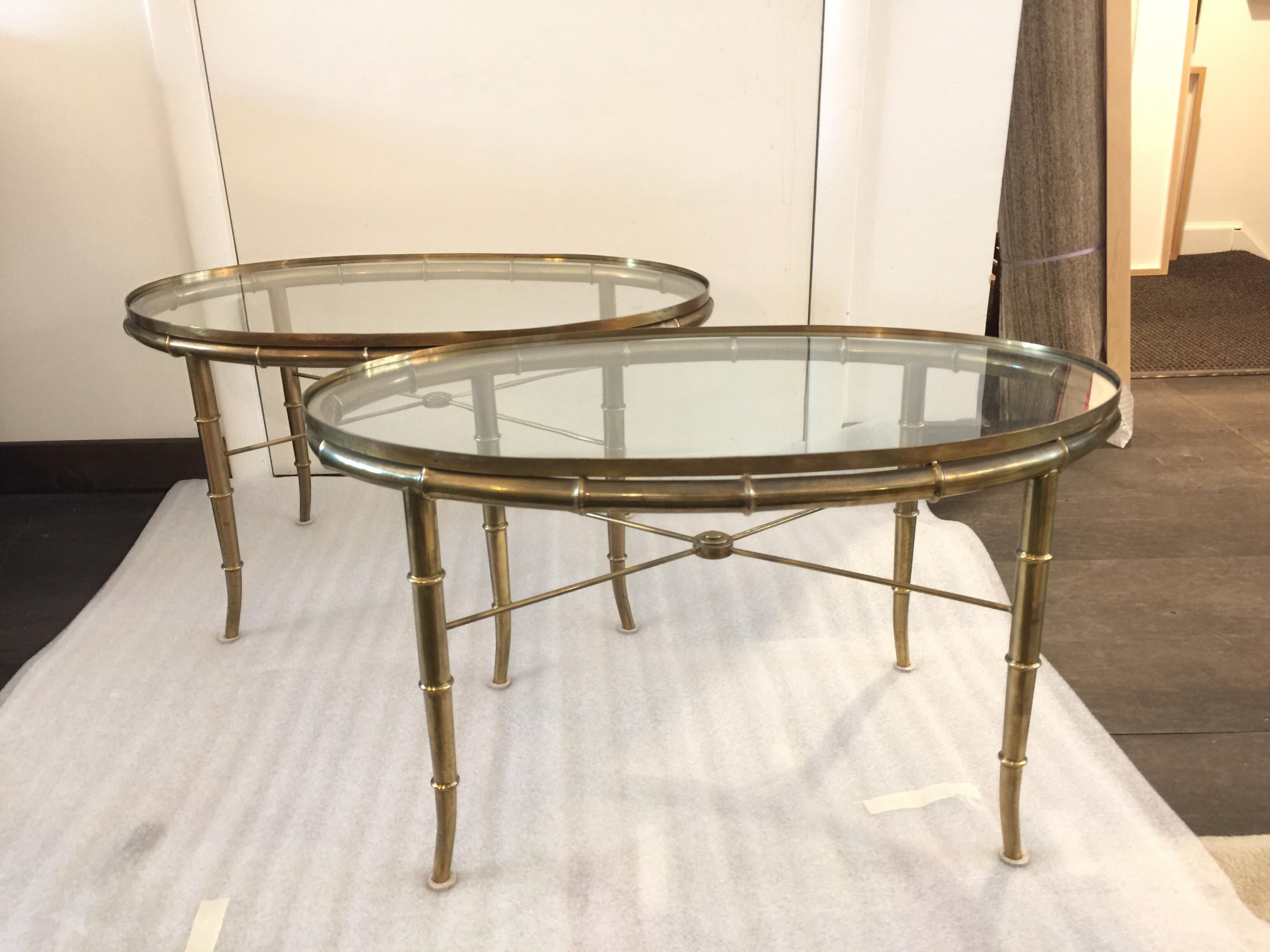 Faux bamboo legs and beautiful original brass patina, glass oval set within a brass tray style top. This is a pair.