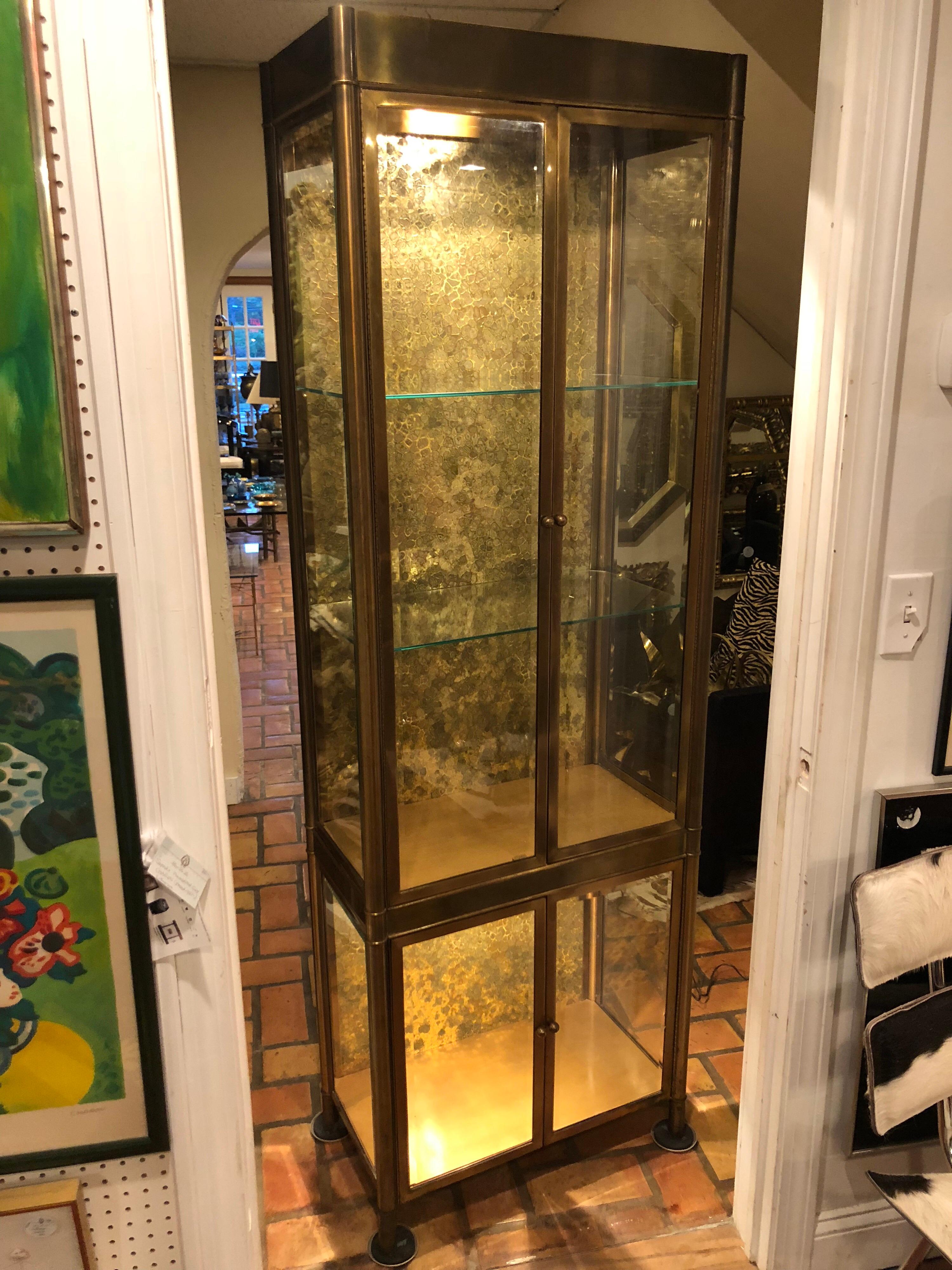 A Mastercraft brass vitrine or etagere. Tortoiseshell - like Mosaic Interior back splash, lighted with glass shelves. The glass on the doors and sides are with thick bevel. Is wired for lighting for even better display. Great for a dressing room to