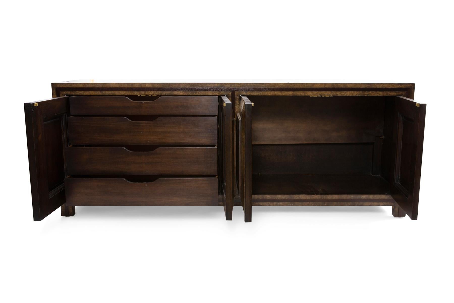 Mastercraft burl and brass sideboard or chest of drawers circa late 1960s. This example has beautiful graining and color to the burl that makes it appear like tortoise shell.
Door fronts have inset patinated brass fronts.