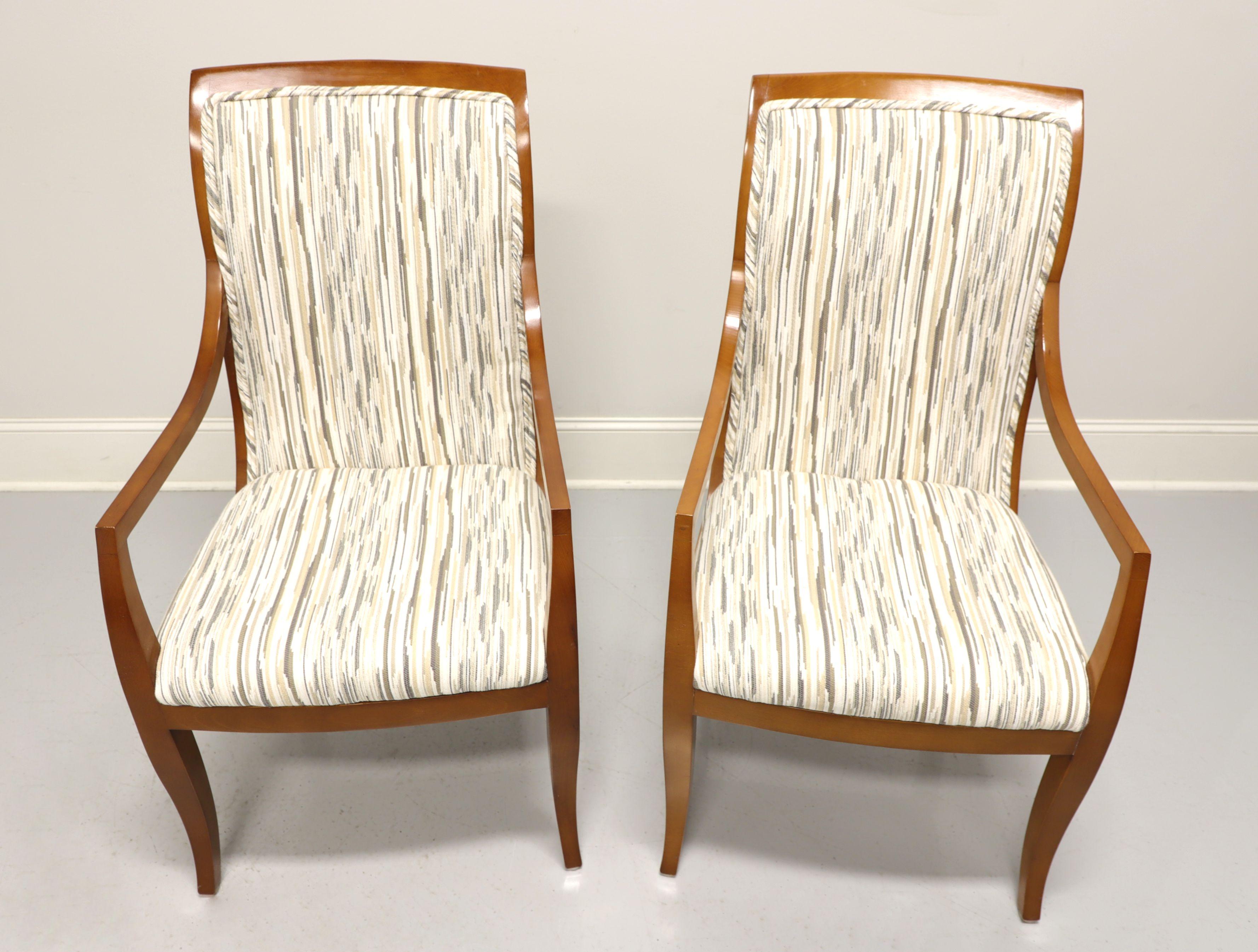 A pair of contemporary style dining armchairs by Mastercraft, a division of Baker Furniture. Solid hardwood with multi-color neutral pattern fabric upholstered backs and seat. Tall rectangular shaped backs, gently sloped arms and saber legs. Made in