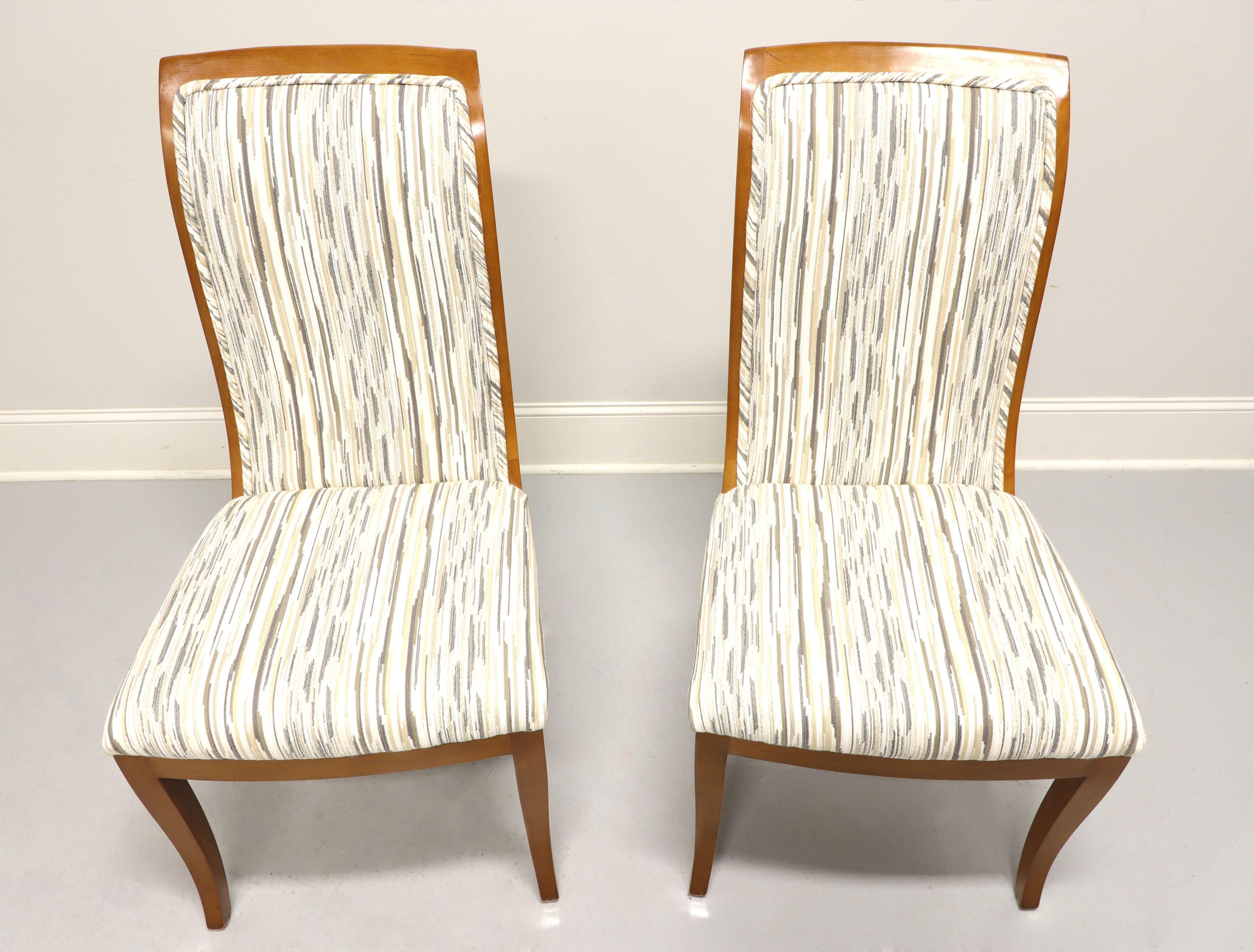 A pair of Contemporary style dining side chairs by Mastercraft, a division of Baker Furniture. Solid hardwood with multi-color neutral pattern fabric upholstered backs and seat. Tall rectangular shaped backs and saber legs. Made in Grand Rapids,