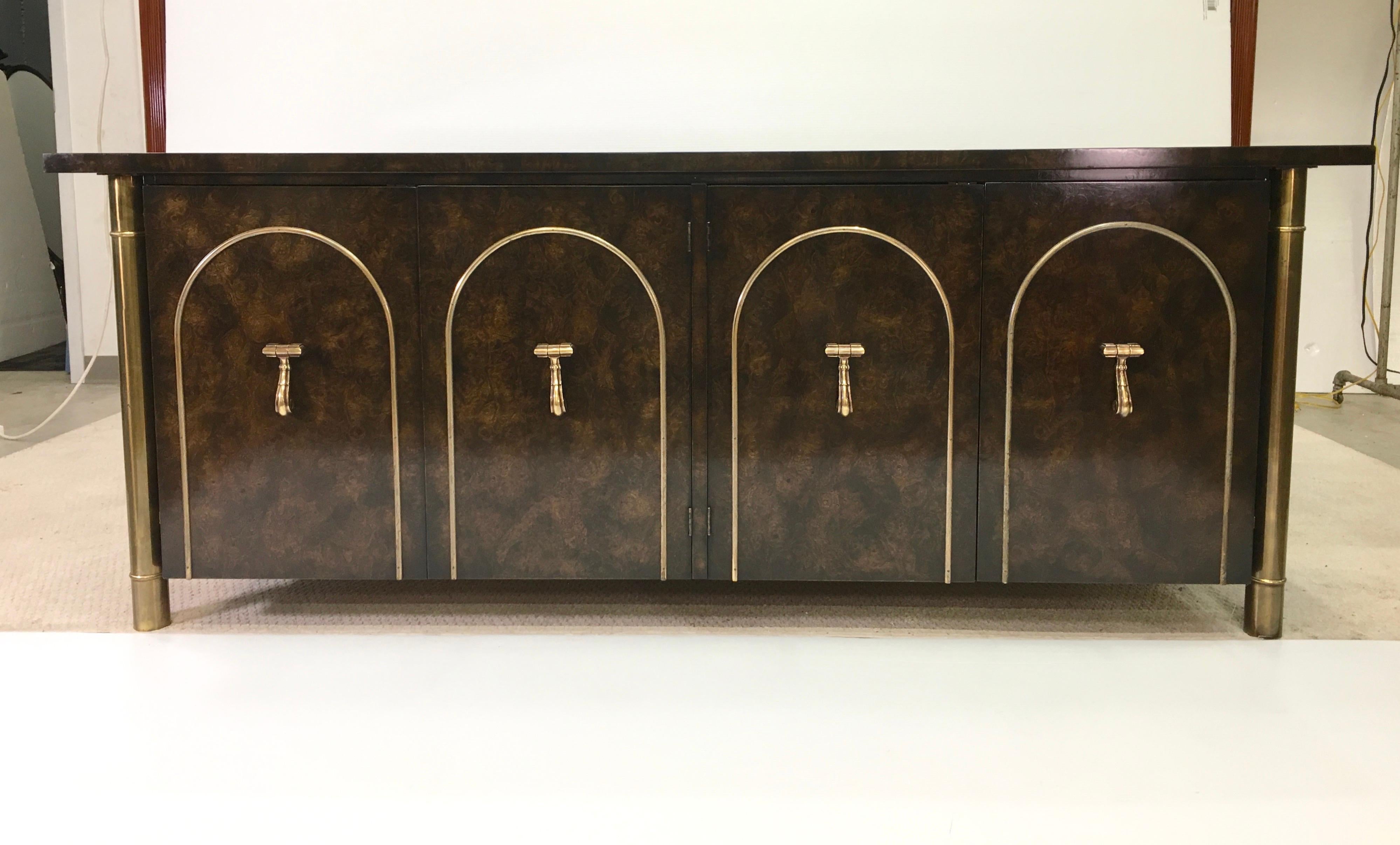 SATURDAY SALE

William Doezema designed for Mastercraft Furniture Co. carpathian elm sideboard consisting of an elongated burl top with rosewood border above a floating case (4 inches off the floor) supported by four round brass bamboo-form legs.
