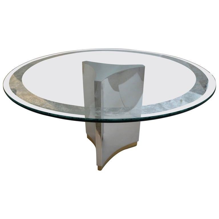This stylish and chic Mastercraft dining table dates to the 1980s and it will make a definete understated statement with its form and use of materials. 

The piece has a base of polished steel and antique goldtone applied finish on the base, and the