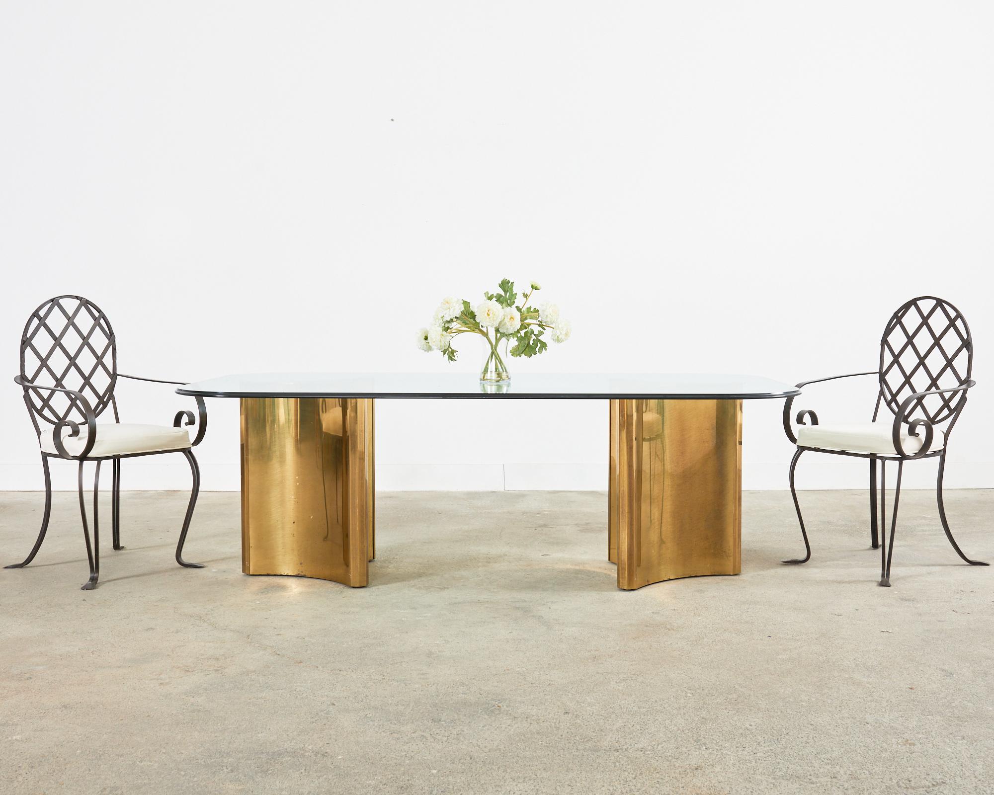 Amazing Mid-Century Modern double pedestal dining table features a pair or polished brass pedestals having a sculpted trefoil form design. The large pedestals measure 21.5 inches across each point to point. The pedestals are topped with a .75 inches