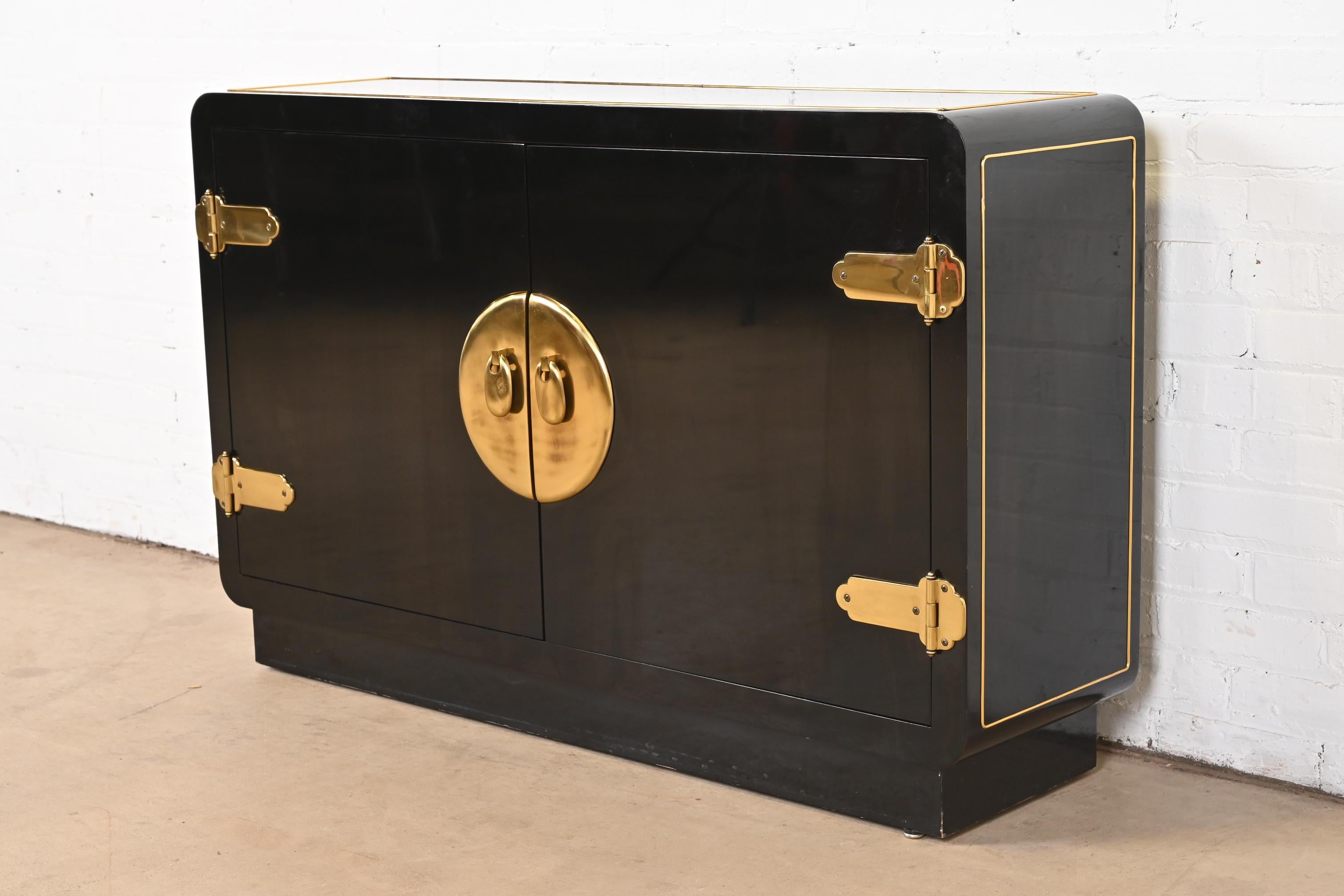 A gorgeous mid-century modern Hollywood Regency dry bar cabinet or bookcase

By Mastercraft

USA, 1970s

Black lacquered wood, with brass trim and Asian-inspired brass hardware.

Measures: 48
