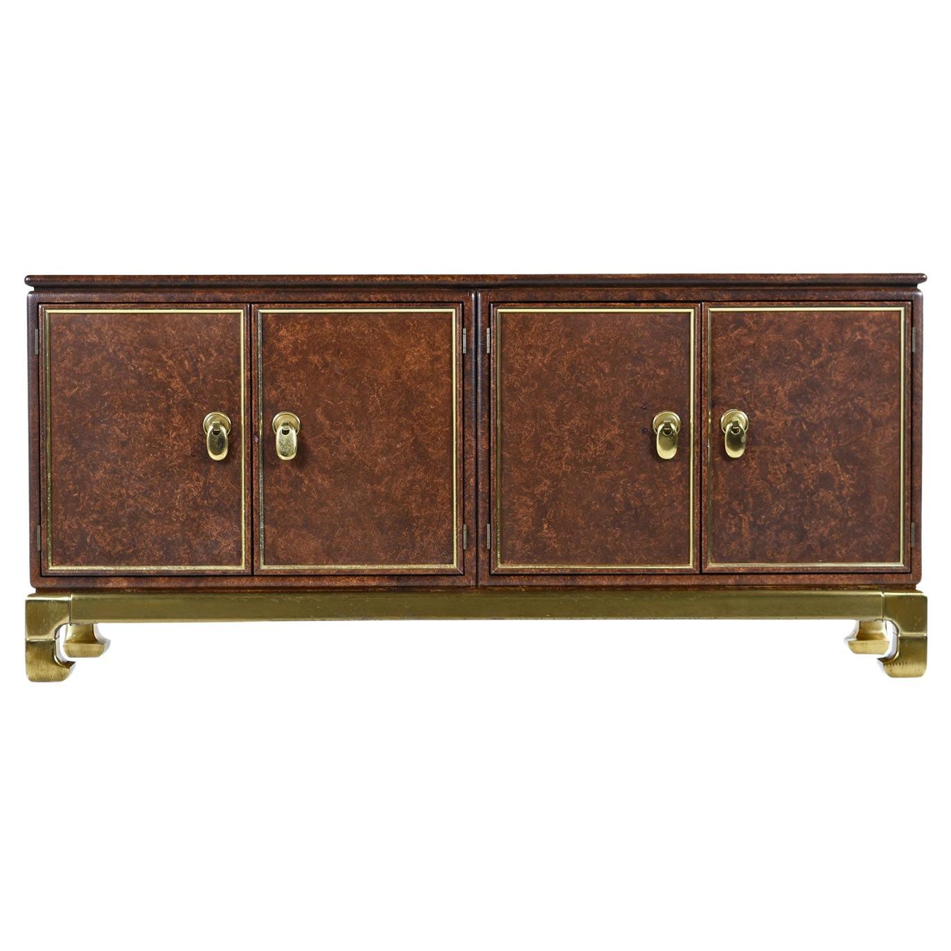 Buffet crédence Mastercraft avec accents en laiton enveloppés de faux cuir. Hollywood Regency et Asian Modern se fondent magnifiquement dans cette armoire étonnante et distincte. Le meuble est orné de poignées décoratives en laiton, d'une base en