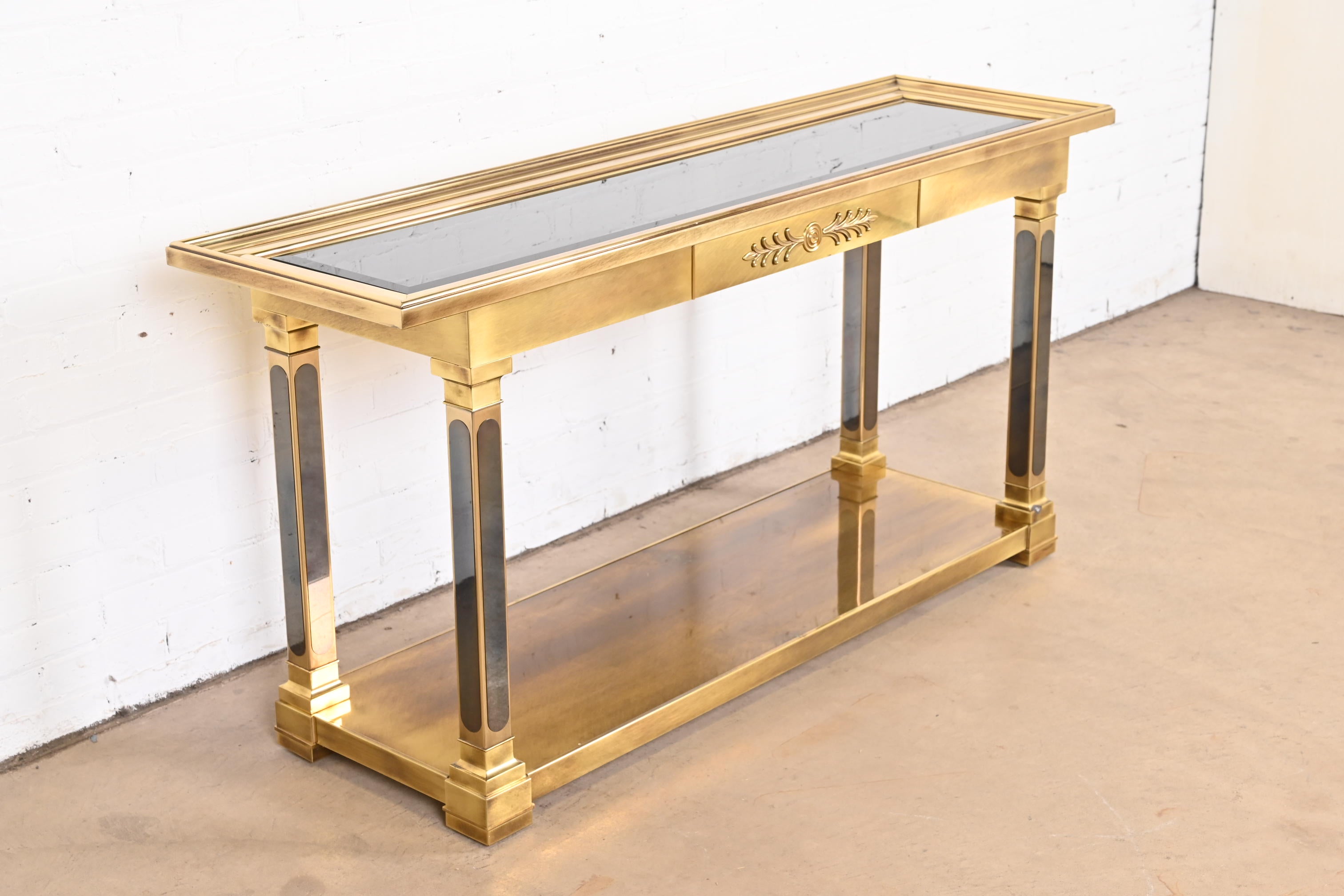 A gorgeous Mid-Century Modern Hollywood Regency console table or sofa table

By Mastercraft

USA, 1970s

Solid brass, with inset smoked beveled glass top.

Measures: 62