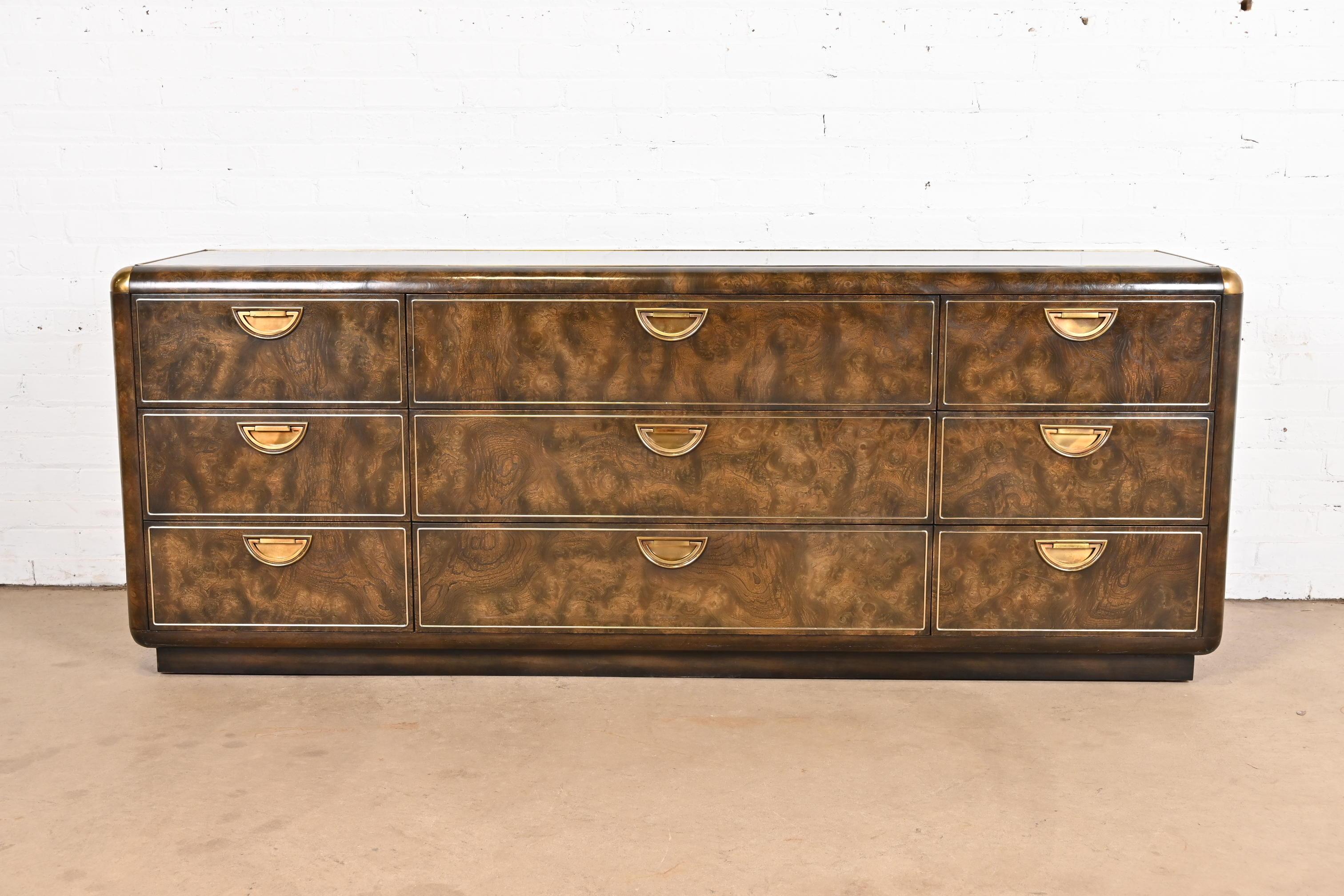 A gorgeous Mid-Century Modern Hollywood Regency Campaign style nine-drawer dresser or credenza

By William Doezema for Mastercraft Furniture

USA, 1970s

Burled Carpathian elm wood, with brass trim and accents and original brass hardware.

Measures: