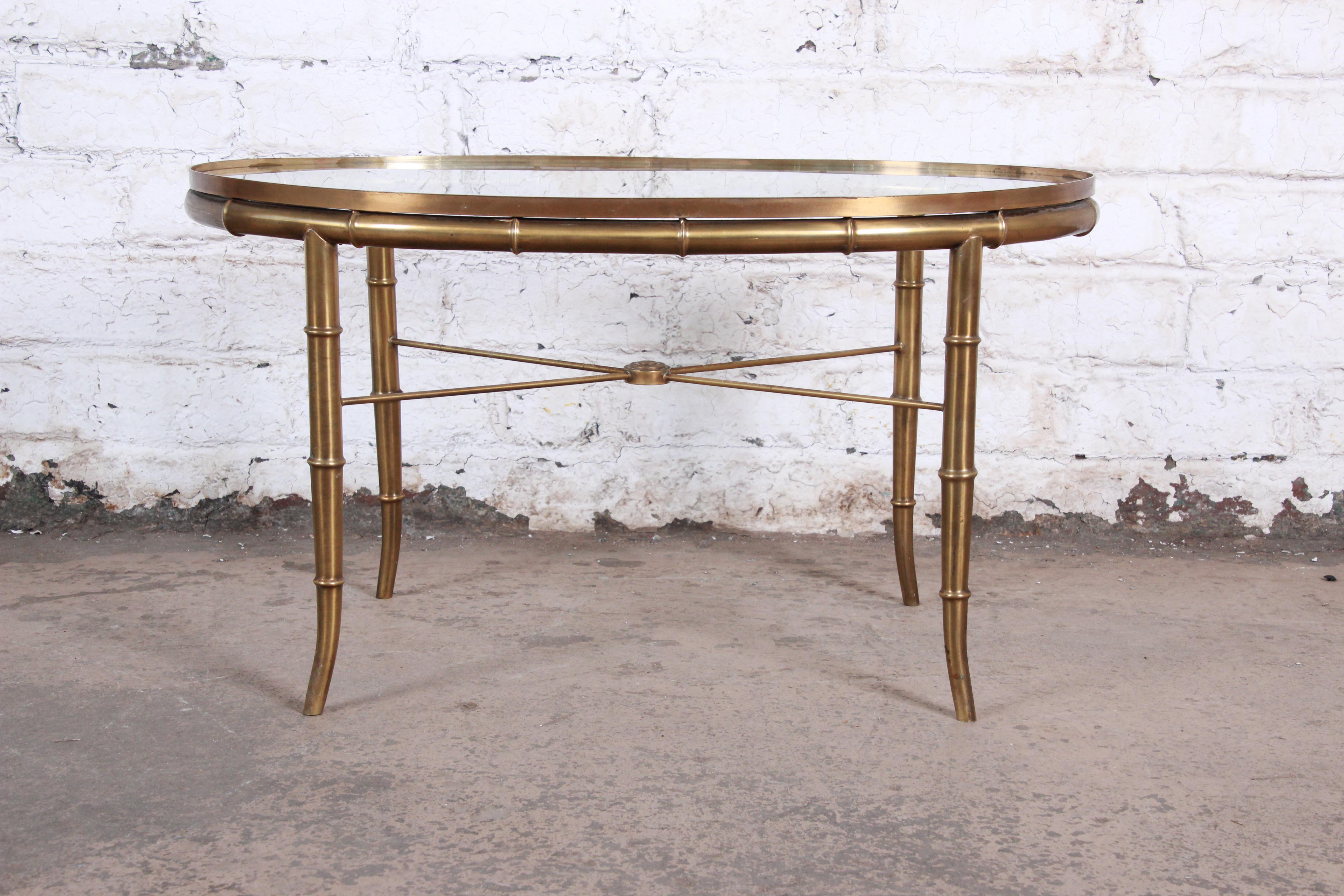 A gorgeous Hollywood Regency Chinoiserie cocktail table or side table by Mastercraft. The table features a stunning faux bamboo brass frame and original glass top. The brass shows beautiful patina from age and use. Overall the table is in very good