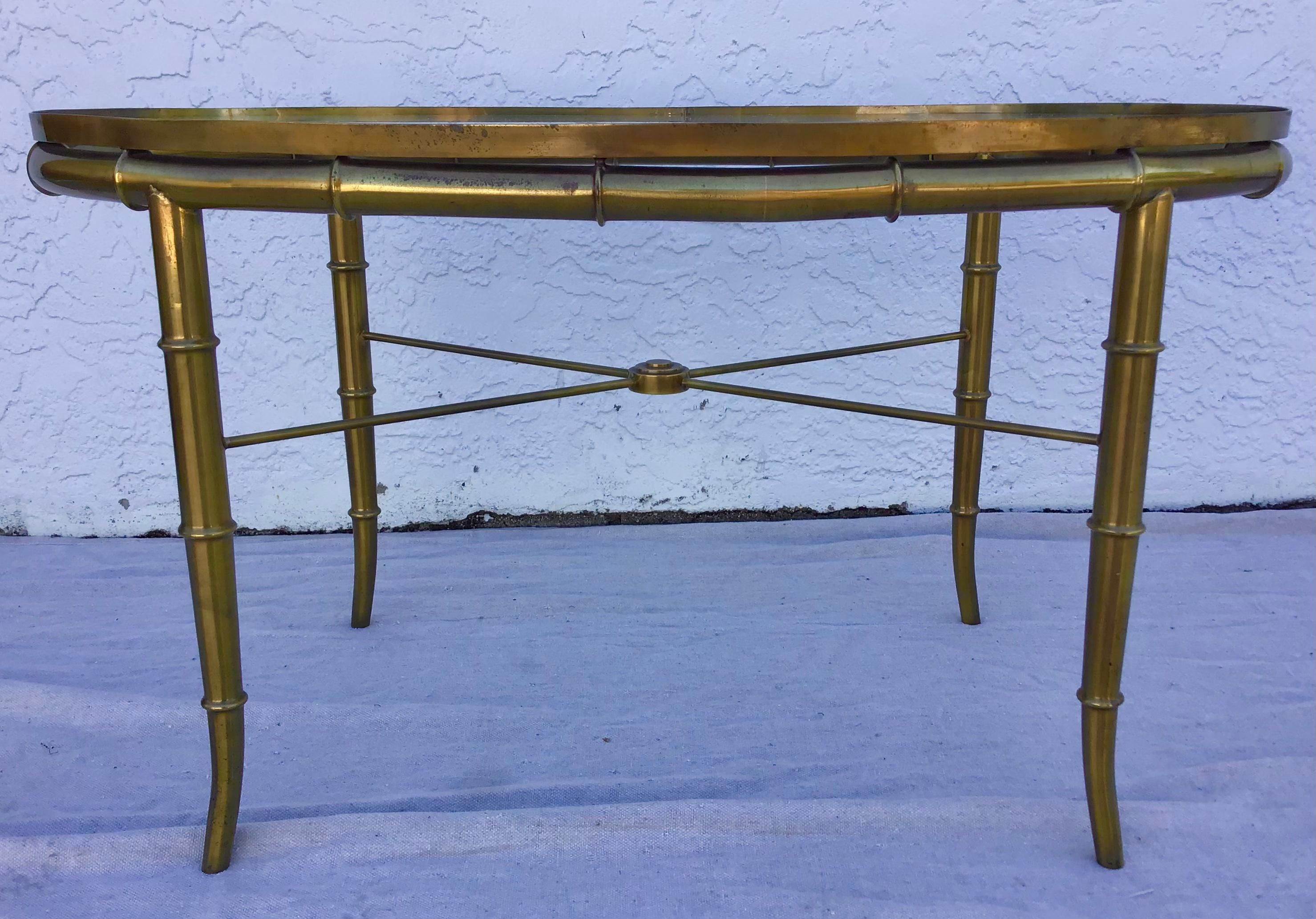 A gorgeous Hollywood Regency cocktail table or side table by Mastercraft. The table features a stunning faux bamboo brass frame and glass top. The brass shows beautiful patina from age and use. Overall the table is in very good original vintage