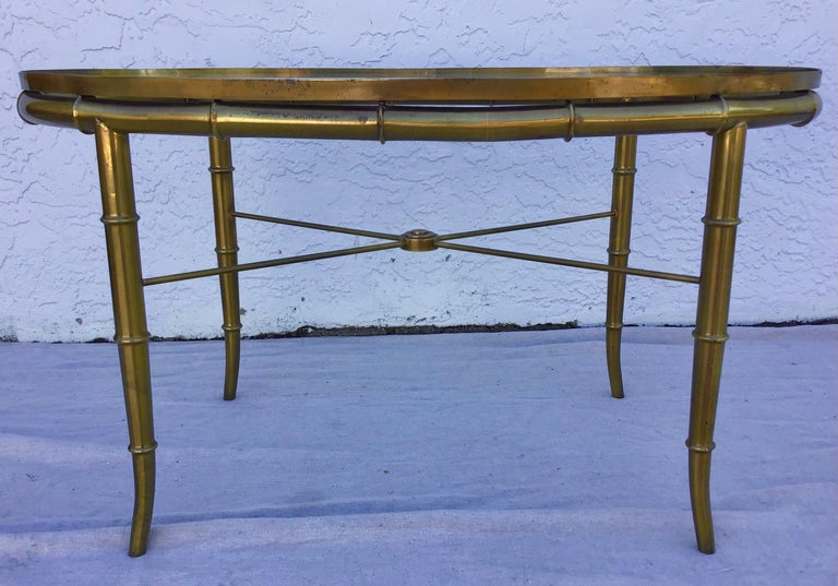 A gorgeous Hollywood Regency cocktail table or side table by Mastercraft. The table features a stunning faux bamboo brass frame and glass top. The brass shows beautiful patina from age and use. Overall the table is in very good original vintage