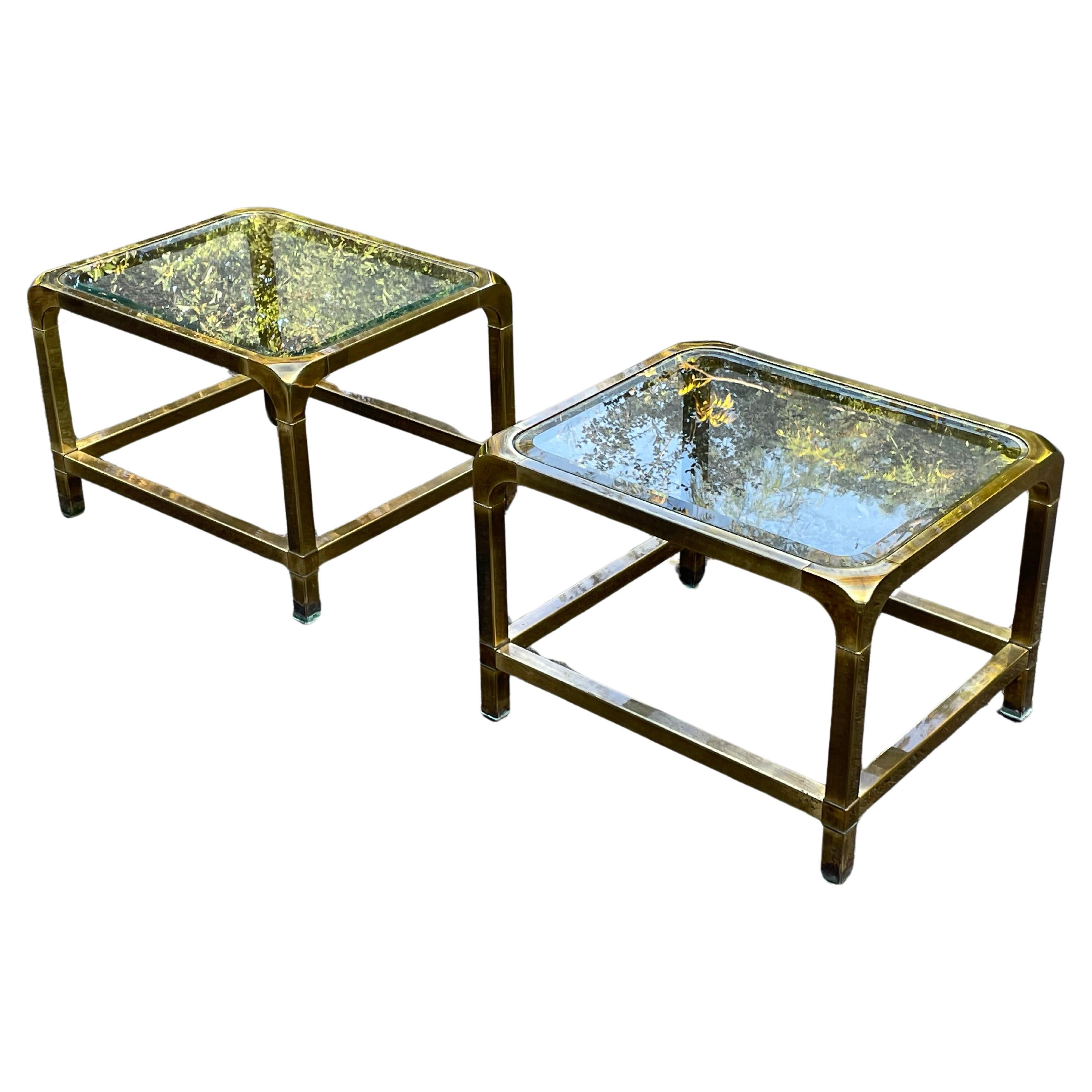 Striking pair of Mastercraft brass end tables with glass tops. Rich gorgeous patina to brass. Glass has bevel. Circa 1970.

We currently have this paired with a pair of Milo Baughman Parsons Chairs in 
Yellow and a legendary Jorge Salzsupin