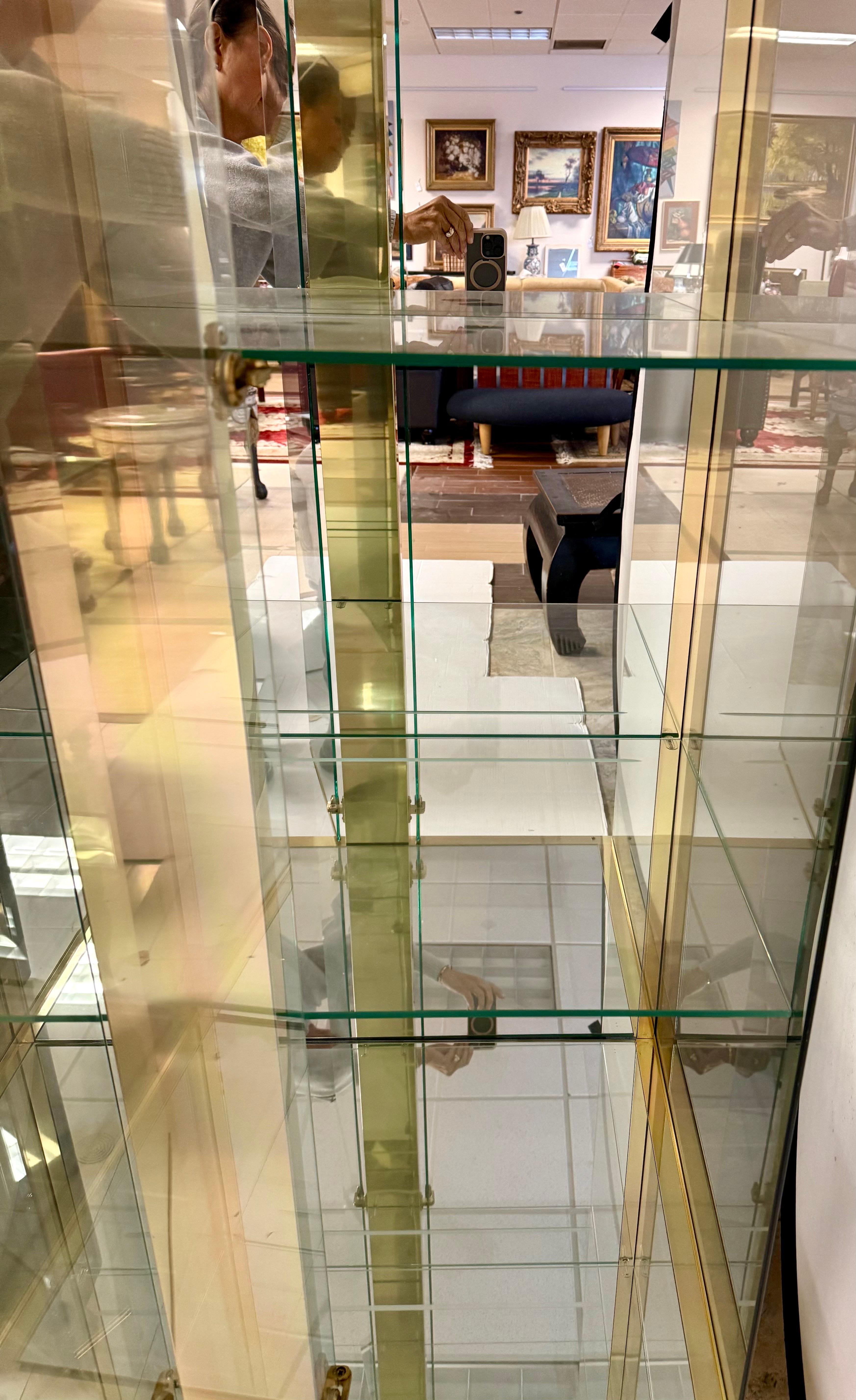 Impresionante vitrina Mastercraft de cristal y latón de mediados de siglo, con iluminación totalmente eléctrica y estantes interiores de cristal para exponer tus preciadas posesiones.  ¿Por qué no poseer lo mejor?