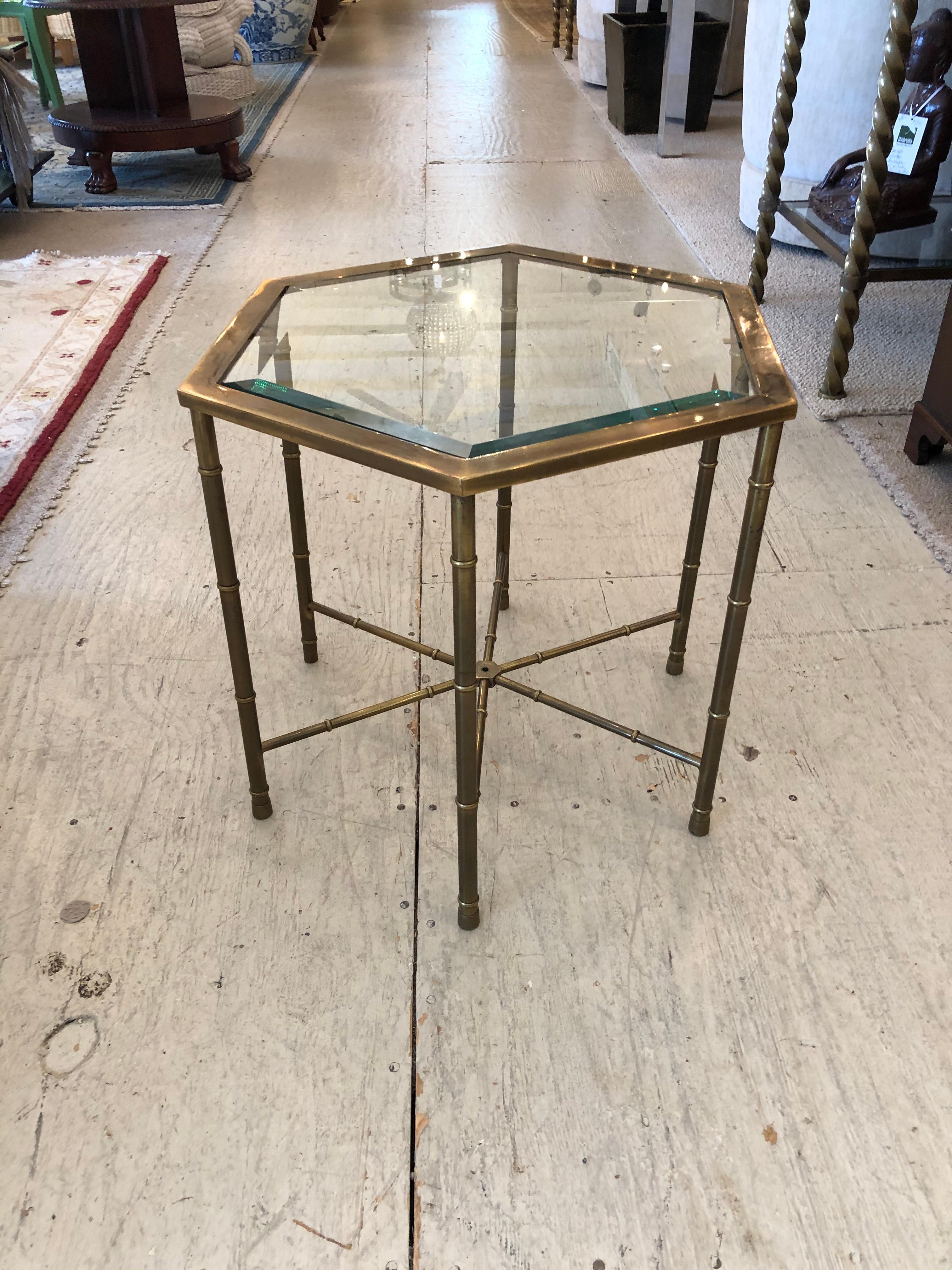 Very versatile sophisticated pair of brass faux bamboo hexagonal martini end tables having original unpolished brass, beautiful criss cross stretchers and beveled glass tops.