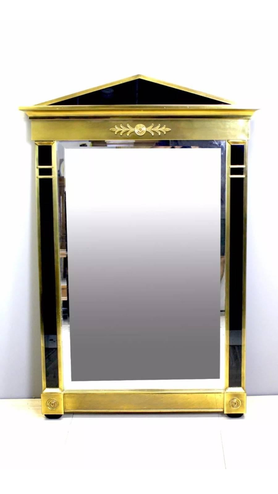 Substantial Mastercraft mirror Designed with solid brass and thick black Lucite with a beveled mirror. Designed in a Modern Empire style, circa 1970s-1980s.
  