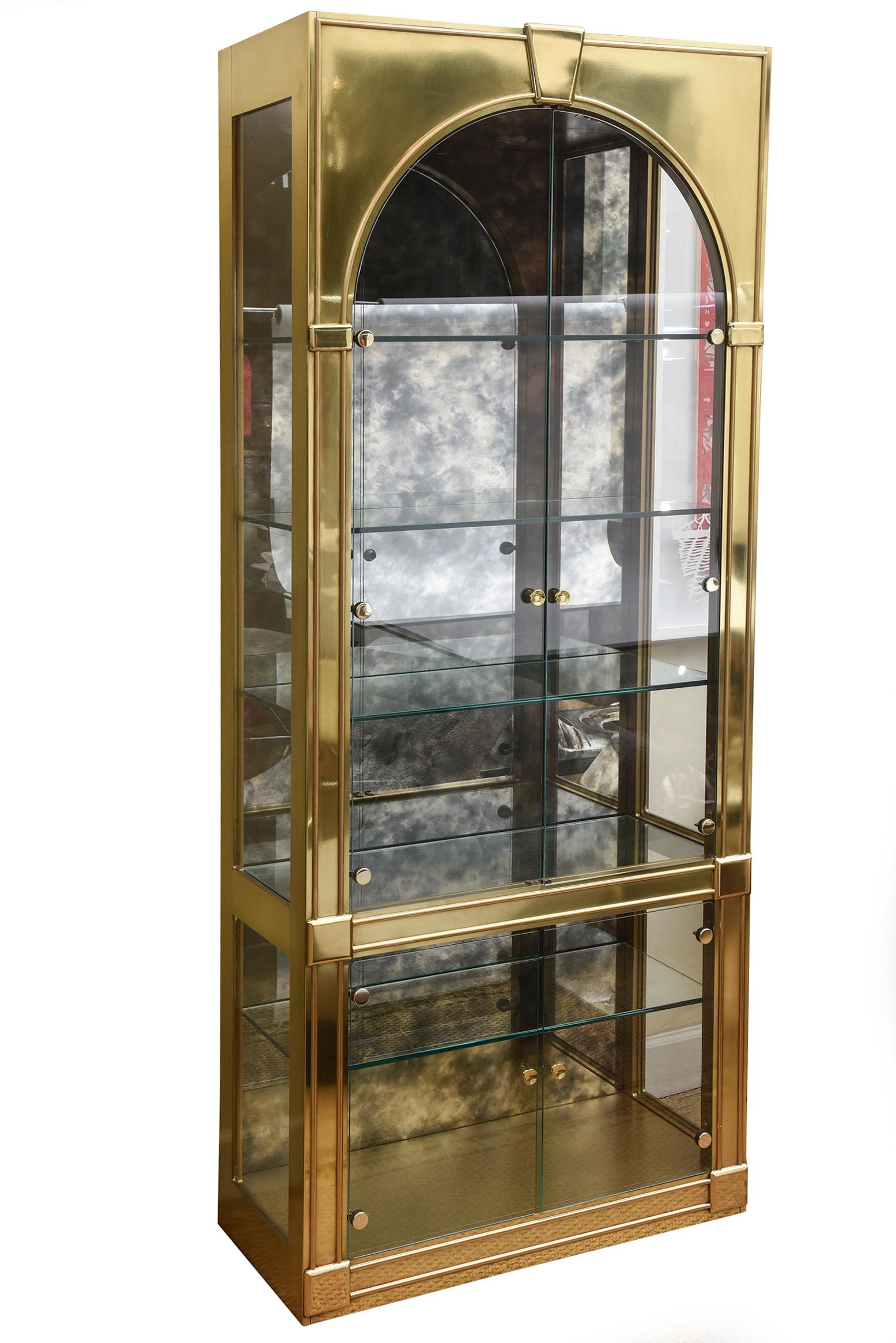These fabulous pair of Mastercraft polished brass vintage vitrines, display cabinets or even dry bar cabinets are from the 1970s and in the Palladian style. They are Hollywood Regency meets the modern 1970s. They have been meticulously polished as