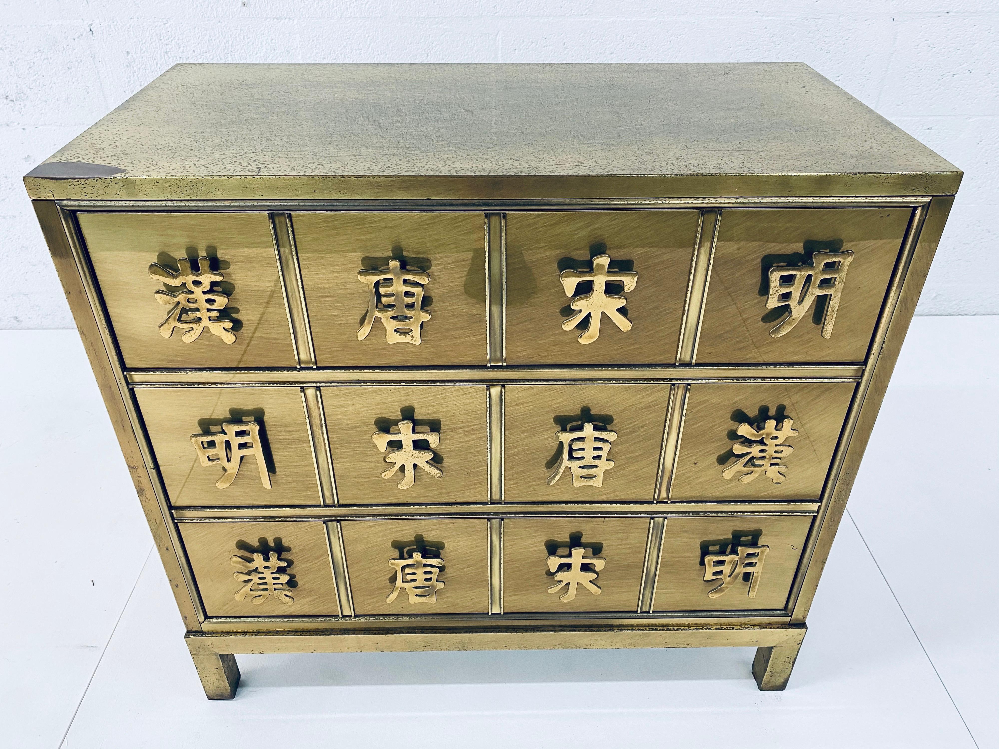 Patinated brass veneer over wood frame commode - dresser or drawers on Parsons base with brass Asian character drawer pulls.