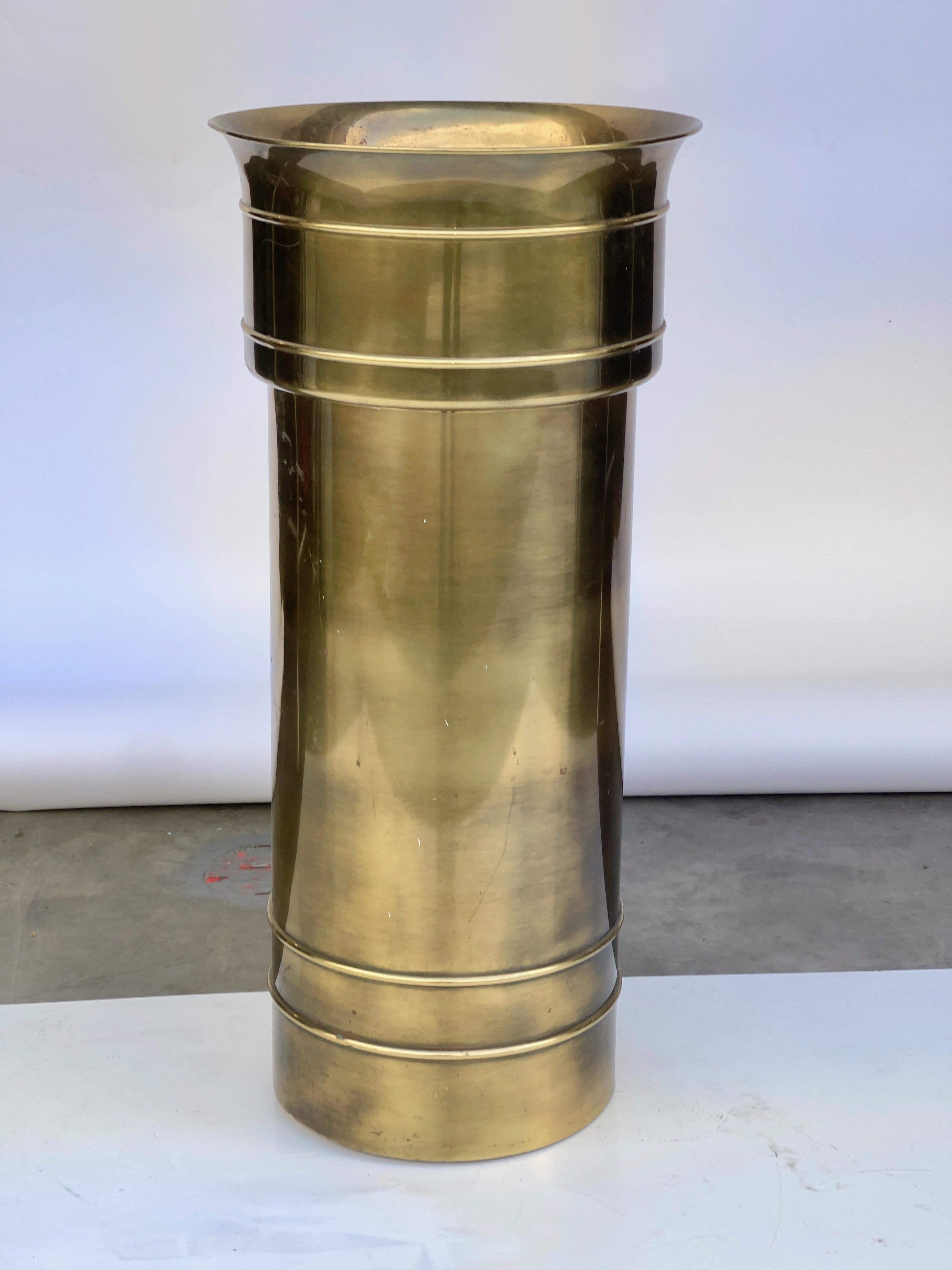 Fabulous pedestal jardiniere by William Doezema for Mastercraft in their signature patinated brass finish. Base is a straight round column which has double rings suggestive of bamboo. The integral top bowl of the pedestal flares out slightly as it