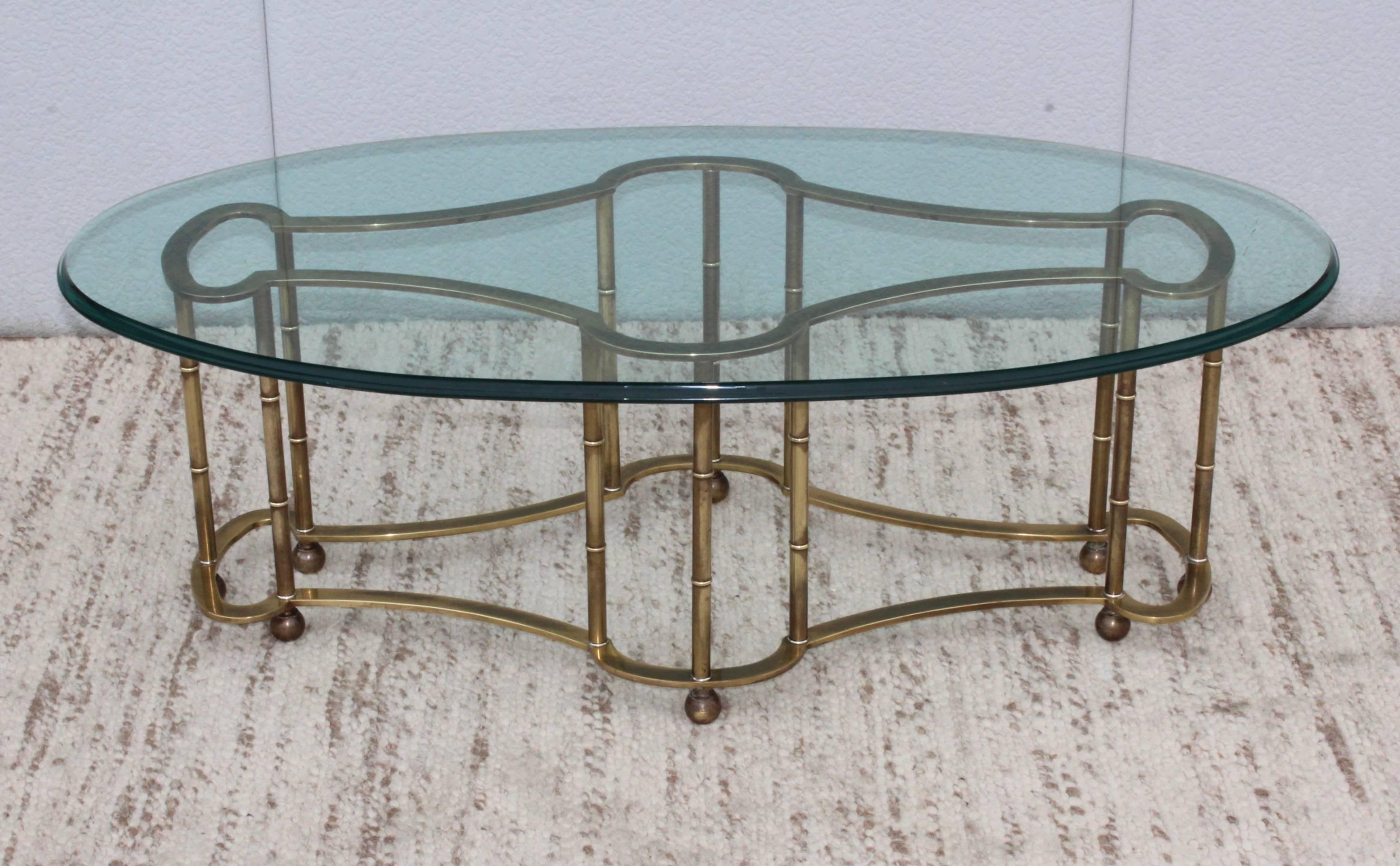 1970s modern Mastercraft racetrack brass coffee table with oval bevelled glass top.