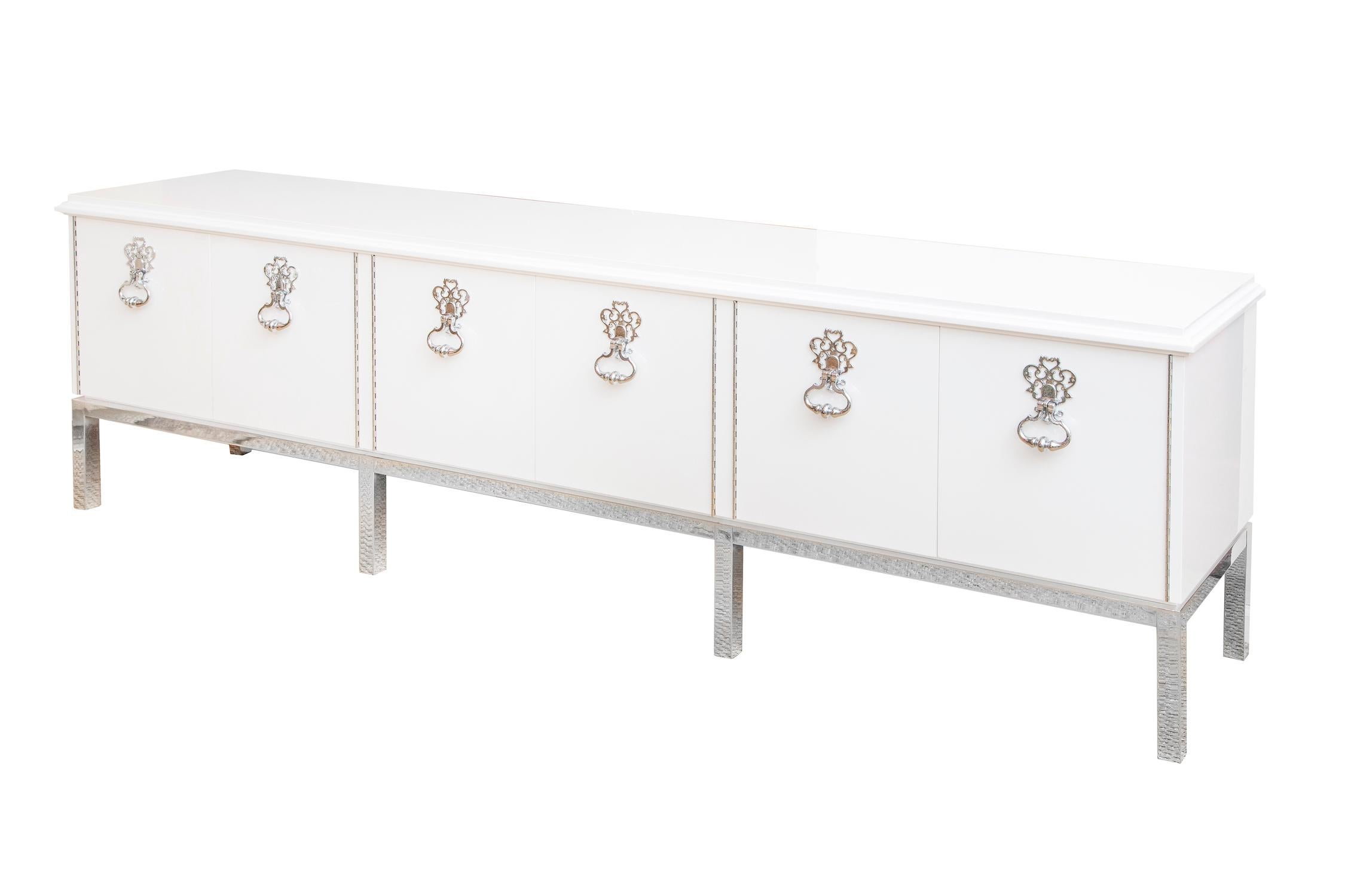 This absolutely stunning very gloriously restored Mastercraft white lacquered over mahogany wood long cabinet, buffet or console was a custom piece at the time of 1975. This magnificent piece has door knocker chrome plated over bronze dramatic