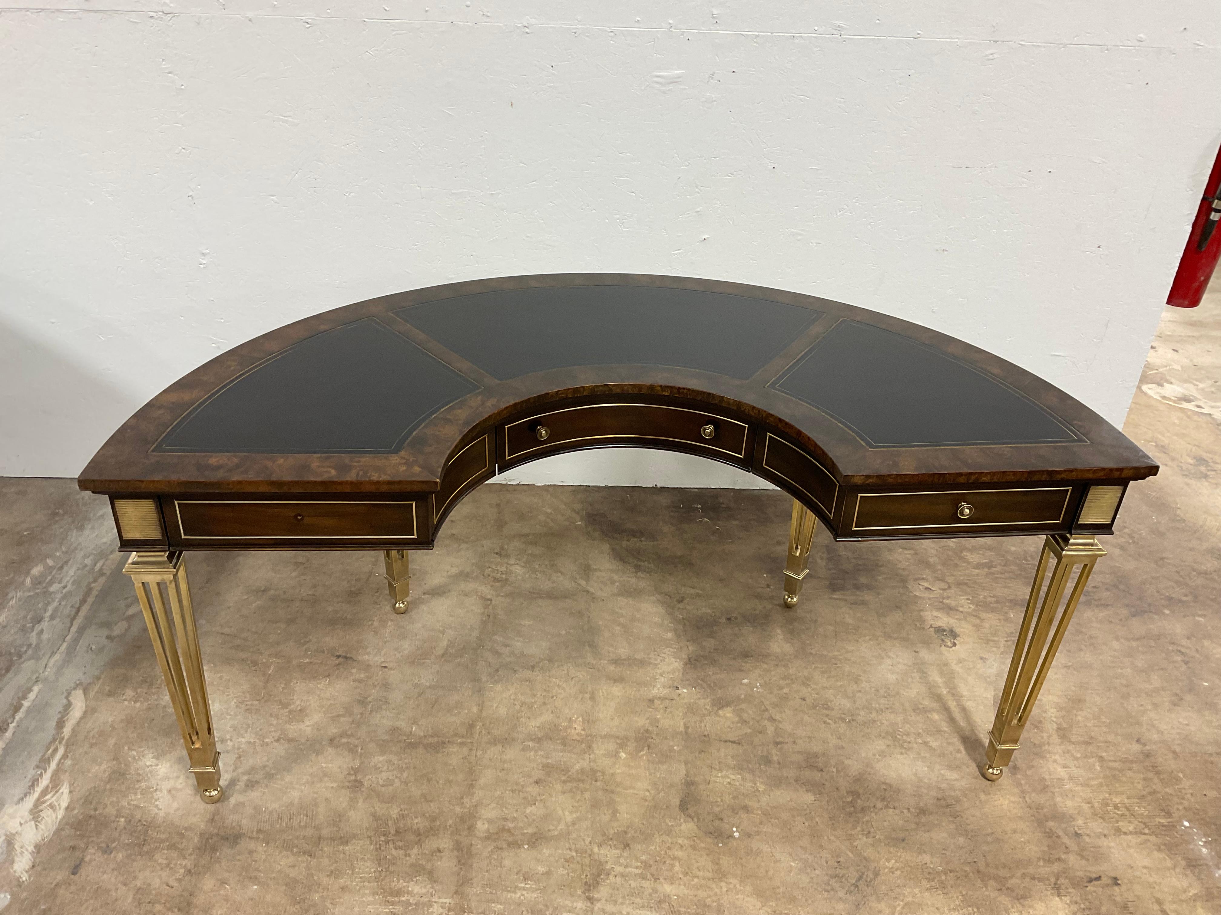 Good looking semicircular desk by  Mastercraft. ( no label)  Their pieces are very distinctive, and easily recognizable. Solid brass , open legs with Amboyna wood top , and black leather work surfaces. 3 drawers across the top with brass hardware.