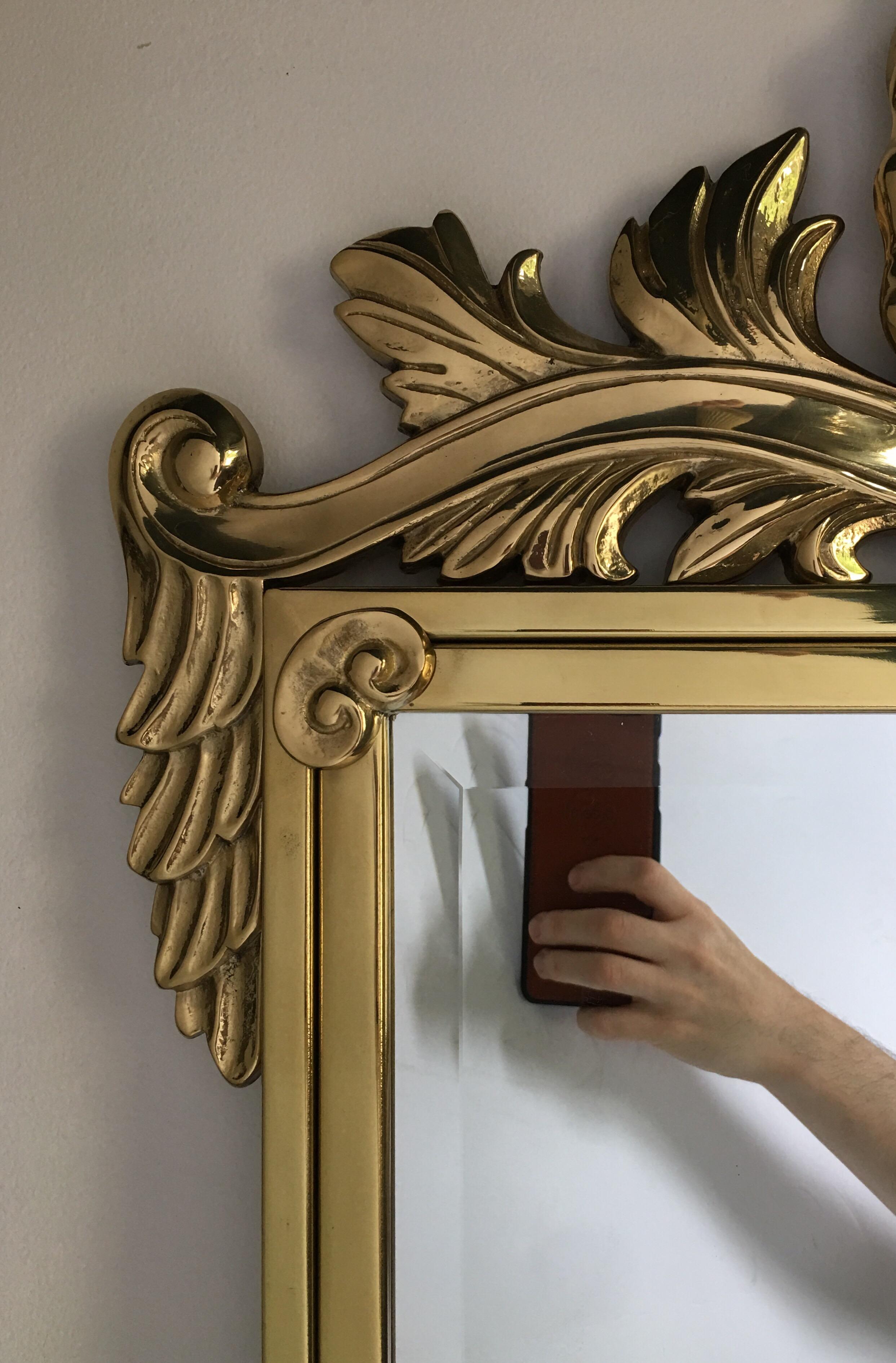 Miroir mural décoratif italien en laiton poli de style Hollywood Regency, dans le style de Mastercraft.  Ce grand miroir de forme rectangulaire présente un motif de coquille finement moulé.
