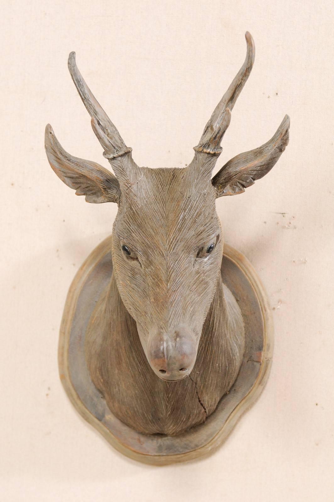 This buck head wood carved wall plaque is an excellent specimen of this master carver's artful work. This vintage hand-carved deer head has expressive features, eyes looking down as if studying something at foot. Meticulous lines make up the fine