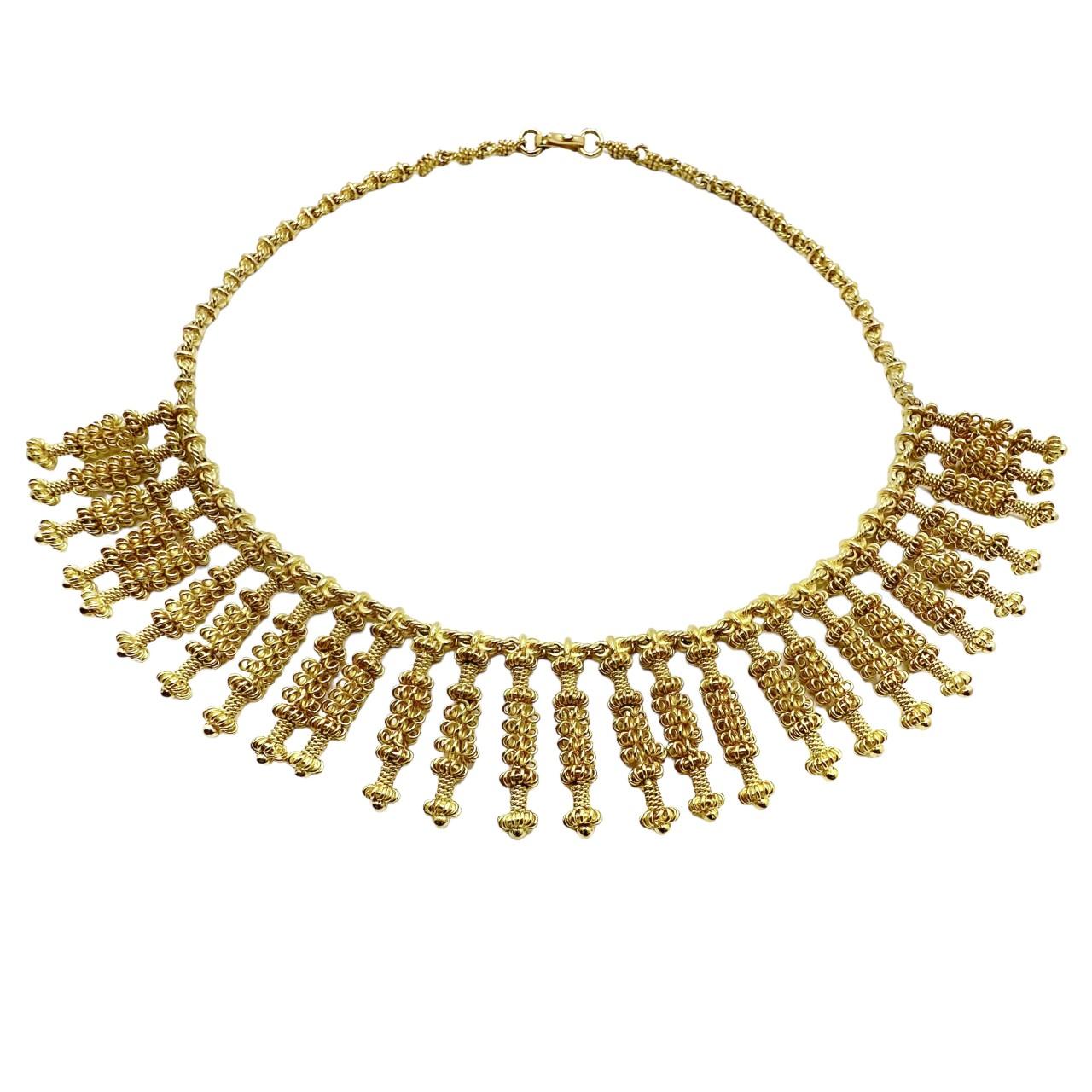 This 18k yellow gold vintage necklace is truly an example of the very best in intricate hand done filigree work. It is comprised of a modified rope link chain from which are suspended a total of seventeen hand filigree wrapped columns, each