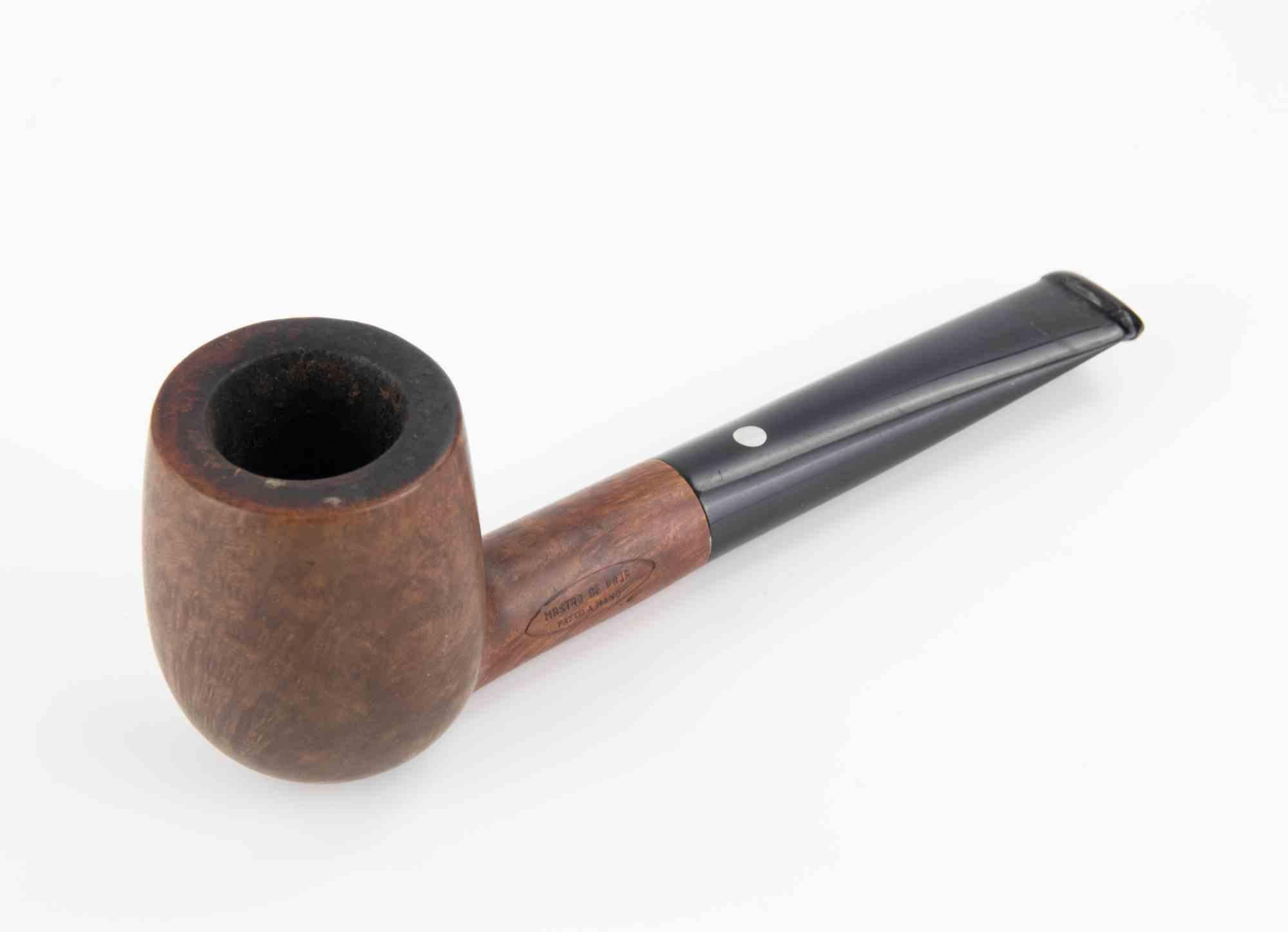 Una auténtica pipa de brezo Mastro de Paja, fabricada a mano en Italia, famosa por su calidad artesanal y su refinada experiencia de fumada. La pipa tiene una forma clásica de billar recto con un acabado marrón suave y cálido que resalta el grano