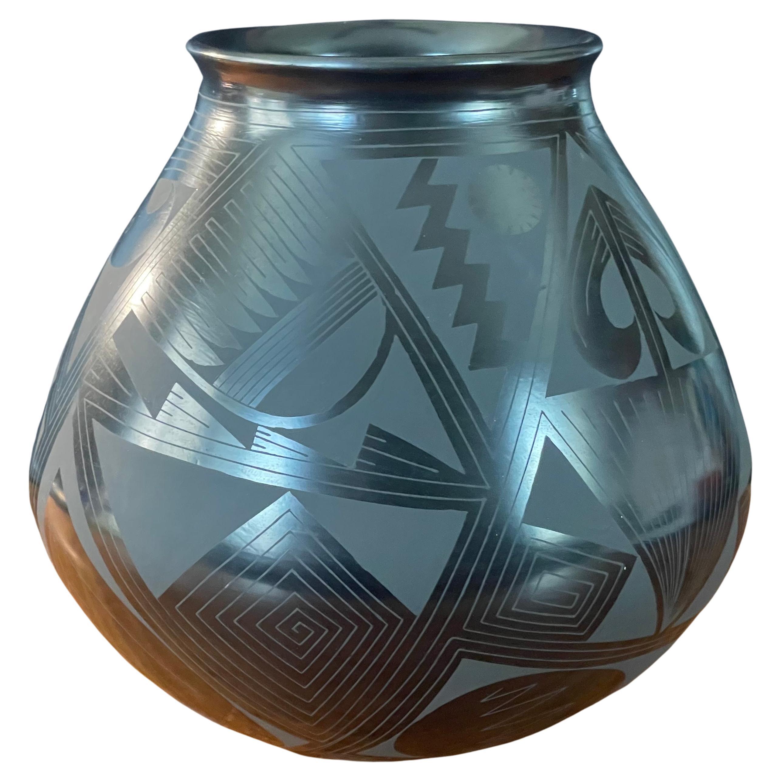 Beautiful hand-turned geometric blackware vase by Octavio Andrew, circa 2000s. The exquisite piece made of naturally black clay has a unique geometric design. This vase is in very good condition and measures 6.5