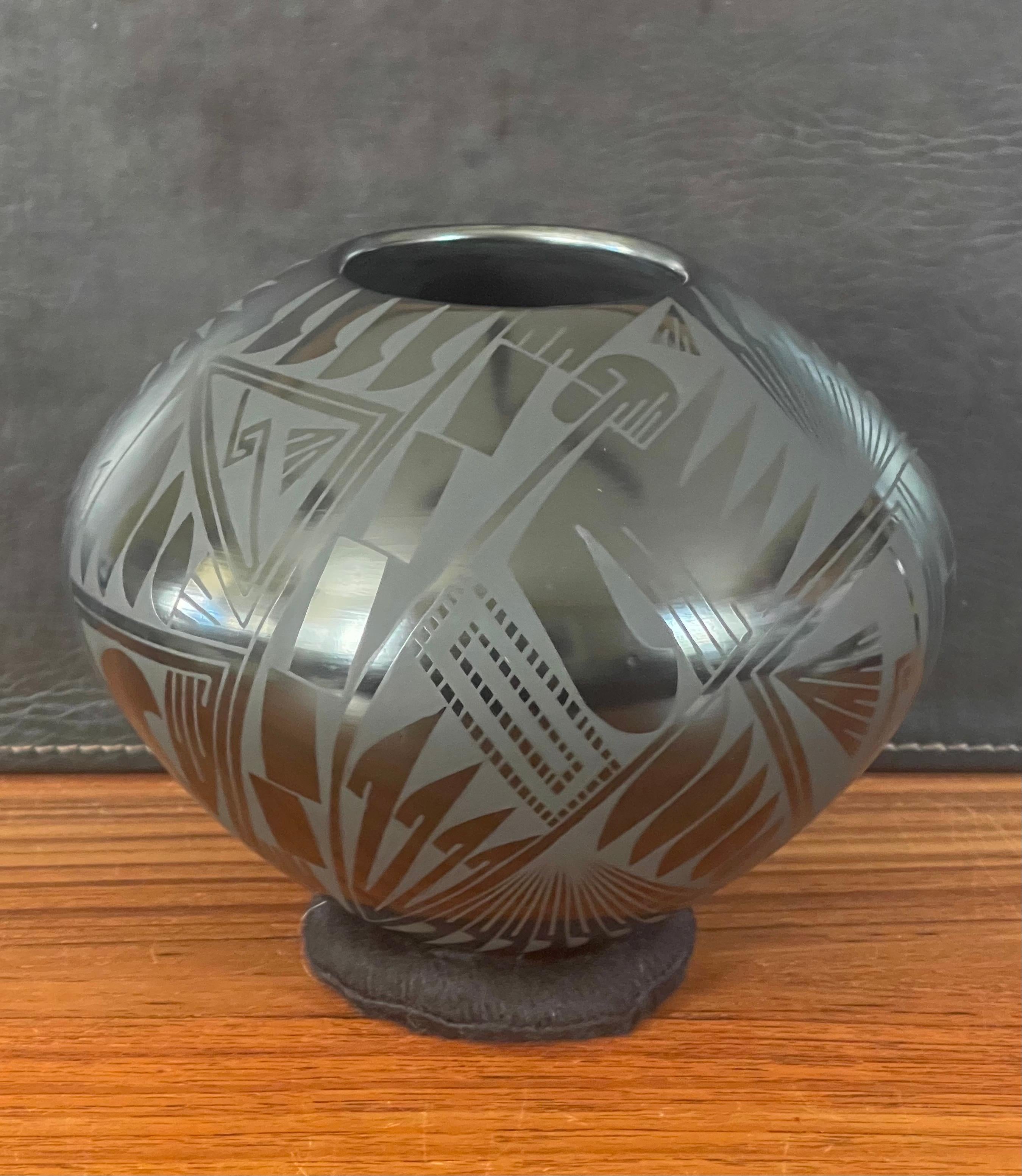 Beautiful hand-turned geometric blackware vase by Oscar Quezada, circa 1990s. The exquisite piece made of naturally black clay has a unique geometric design. This vase is in very good condition and measures 8