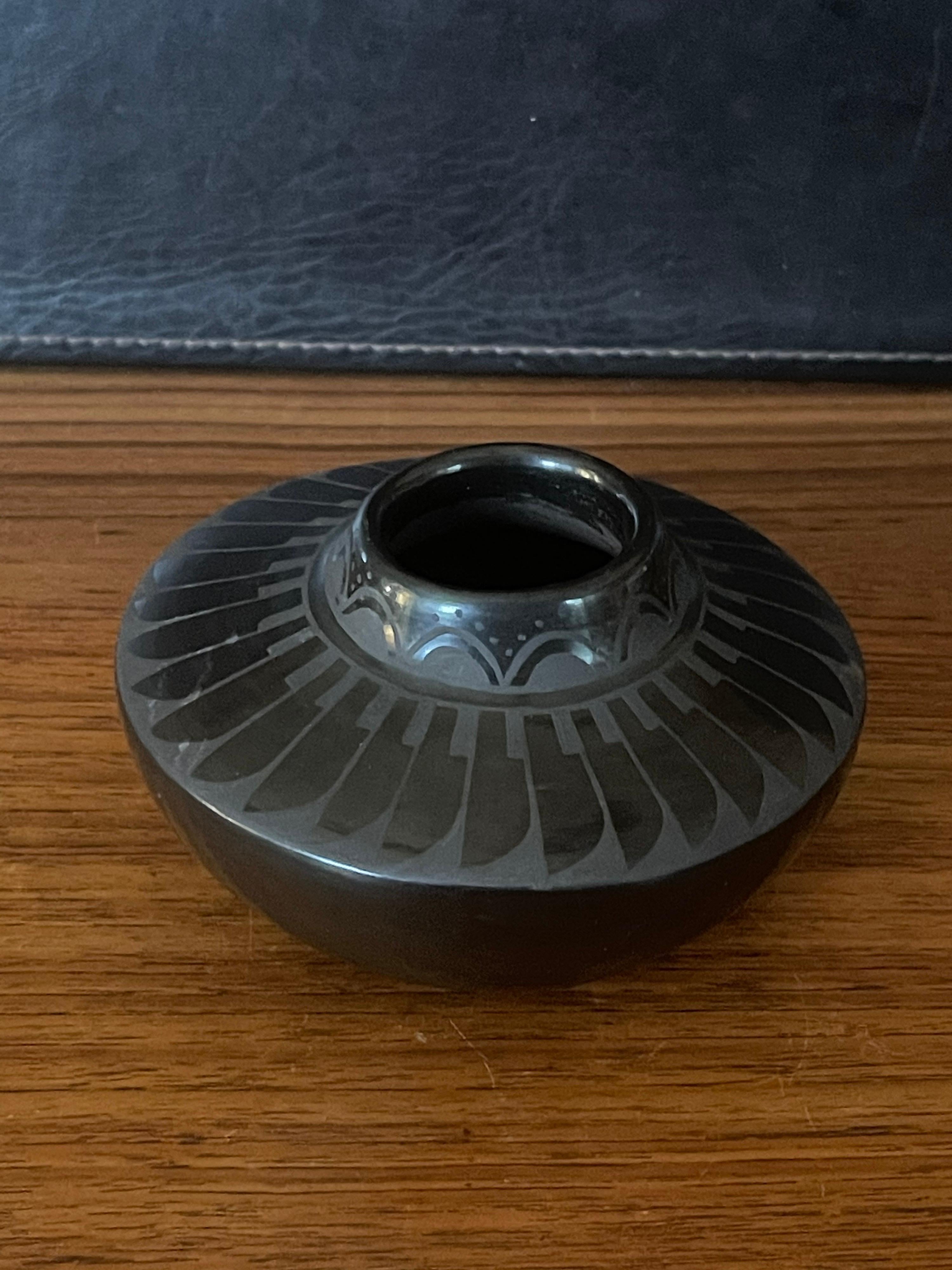 Beautiful hand-turned geometric blackware vase by Ramona Tapia, circa 1990s. The exquisite piece made of naturally black clay has a unique geometric design. This vase is in very good condition and measures 5.5