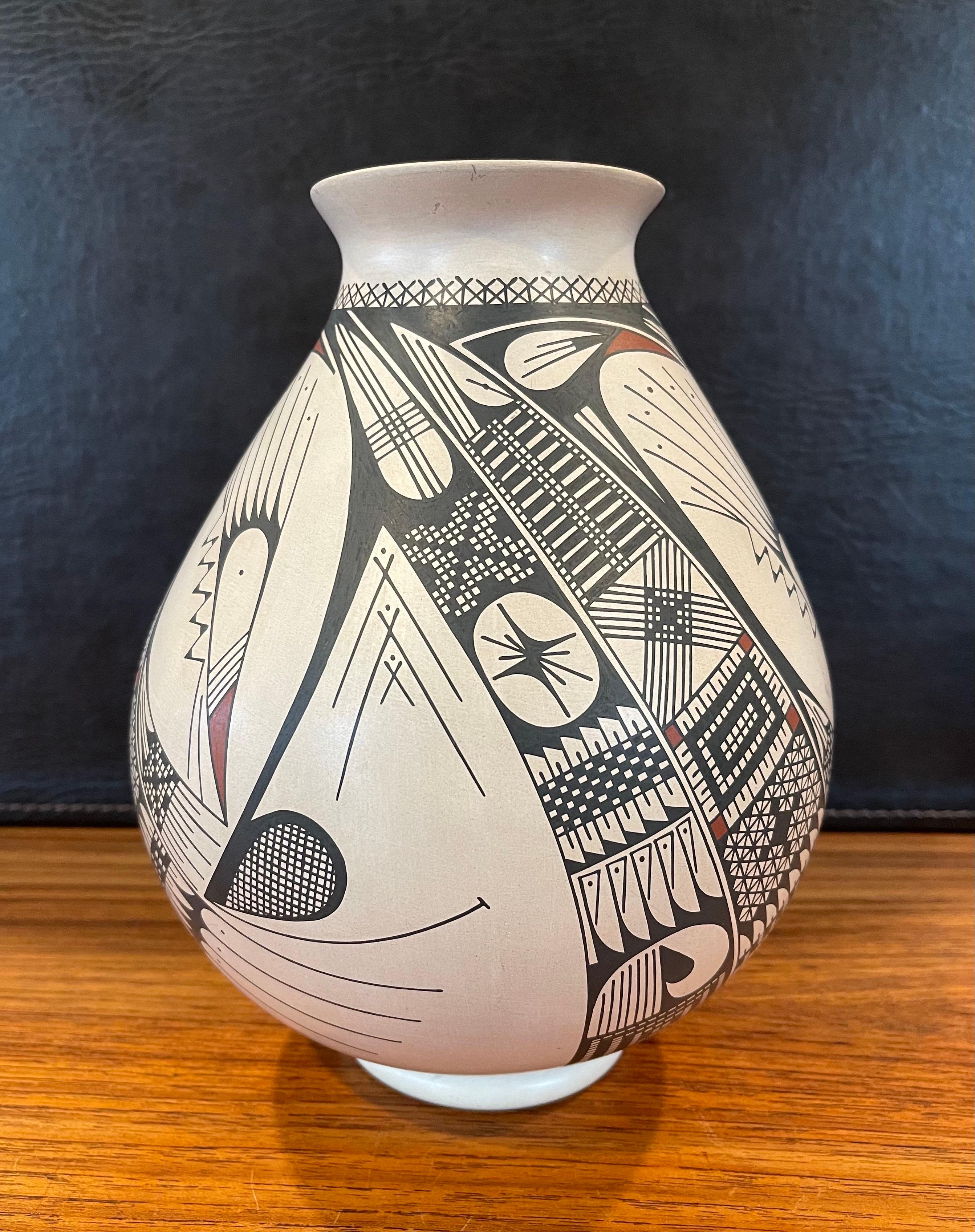 Beautiful hand-turned polychrome Mata Ortiz geometric vase by Celia Veloz, circa 1990s. The exquisite piece made of naturally white clay has a unique black and brown bird design and a definite Quezada influence. This vase is 7.5