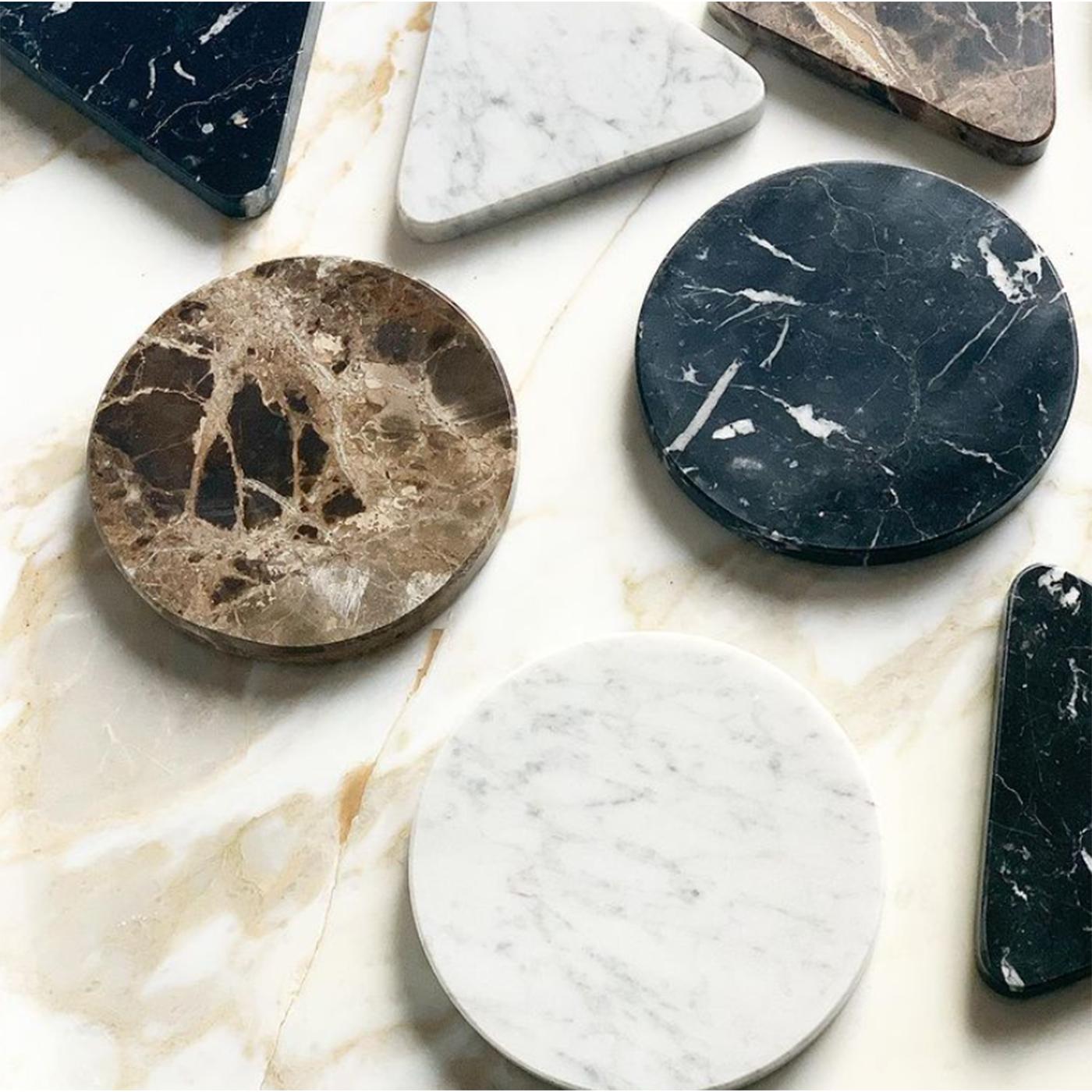 Questa lampada da parete semplice ed elegante, composta da un disco di vetro fuso bianco versato in un piatto opalescente e decorato con un prezioso cerchio di marmo nero, è un omaggio alla sensualità di Mata Hari. La ballerina esotica e spia