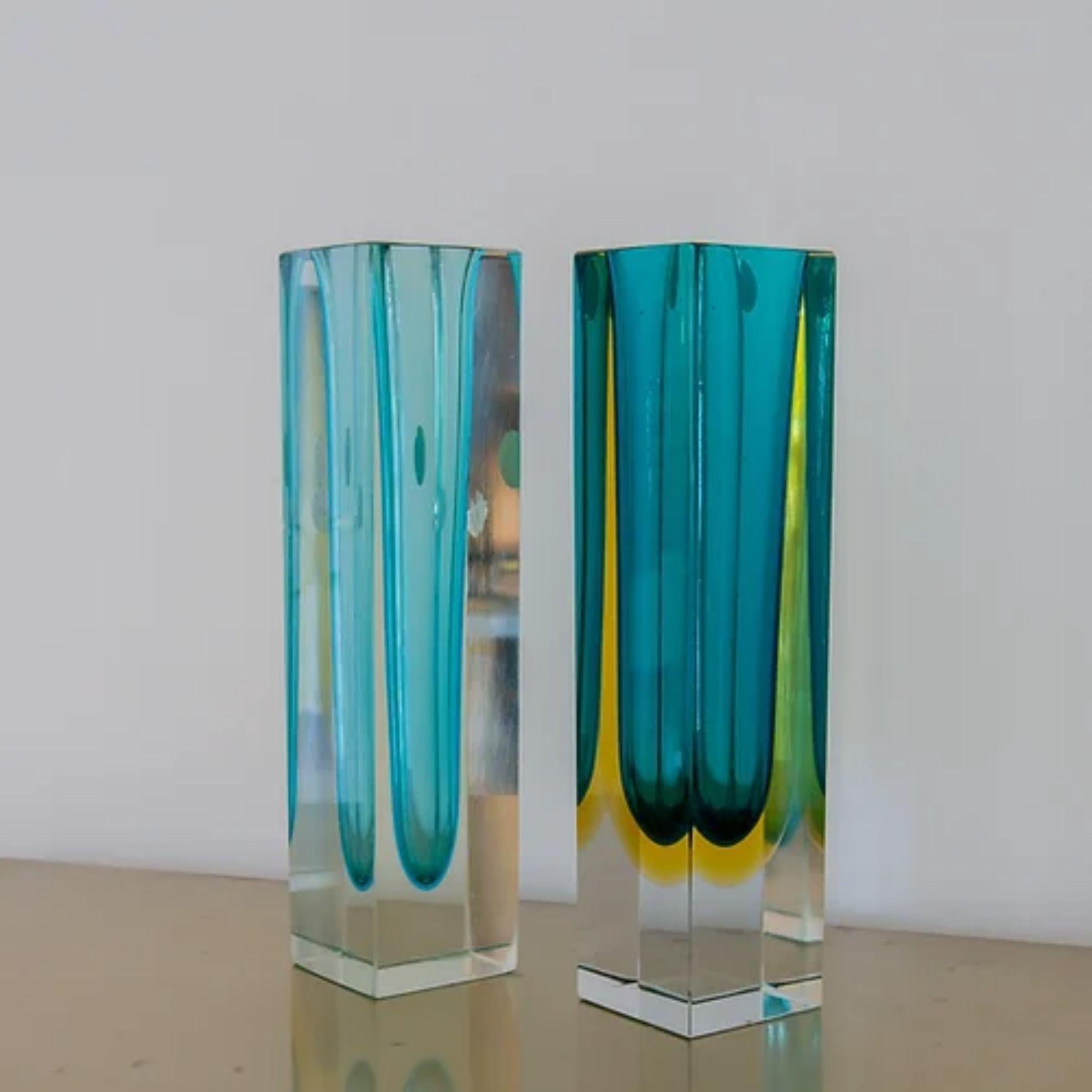 A match pair of turquoise Murano glass vases comprising of: 

A Large Murano Sommerso Glass Vase with a Turquoise Centre Cased in Clear Glass
30cms high x 7cms square

A Large Murano Sommerso Glass Vase with a Turquoise and Amber Centre Cased in