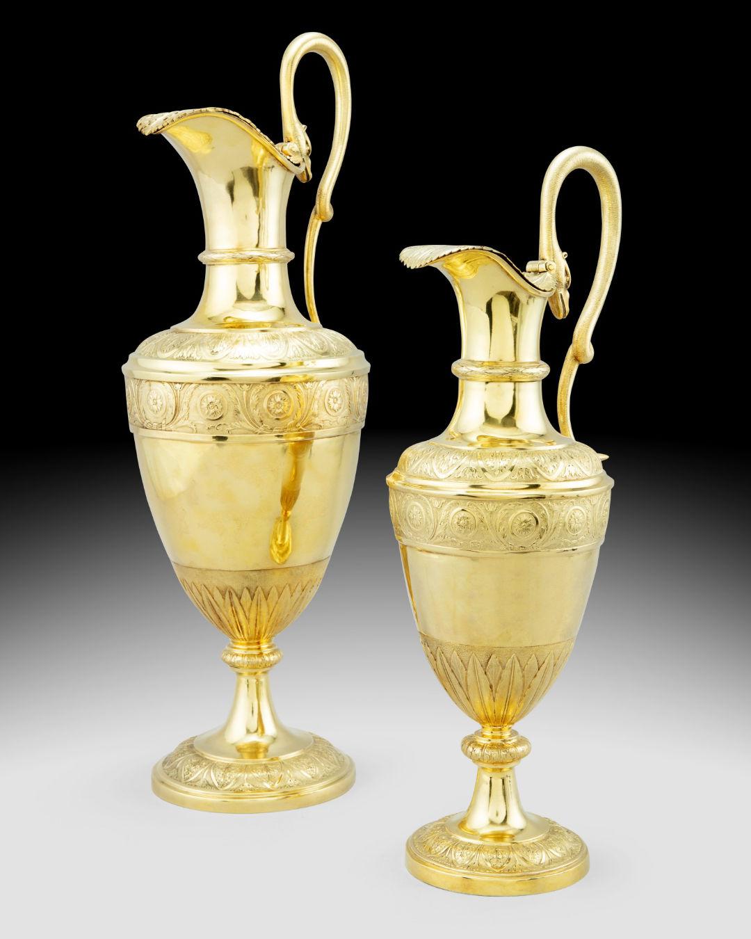 Our pair of elegant silver-gilt ewers are attributed to the Austrian maker, Johann Georg Hann of Vienna, circa 1780-1800. Heights: 17 7/8 and 22 1/2 in; 45 and 57.1 cm.  Total weight: 143 oz, 4,450 g.

Each of almost identical design, featuring