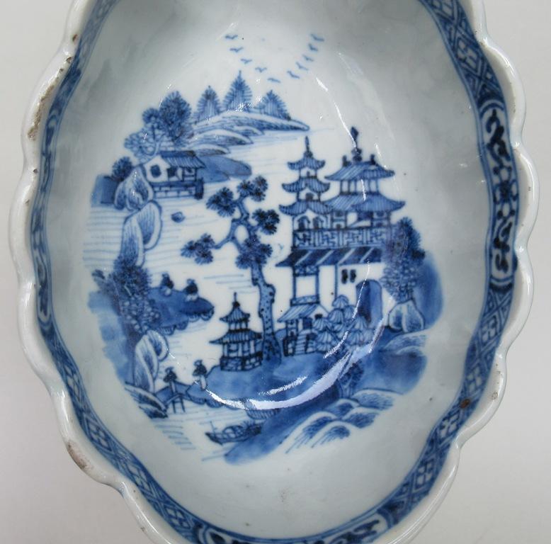 Matched pair of Qianlong Period (1736-1796) Chinese Export Porcelain “English Silver” style sauce boats.

Each of elongated oval form, with applied C scroll handles, decorated in underglaze blue with floral sprays and entwined leaves and a busy