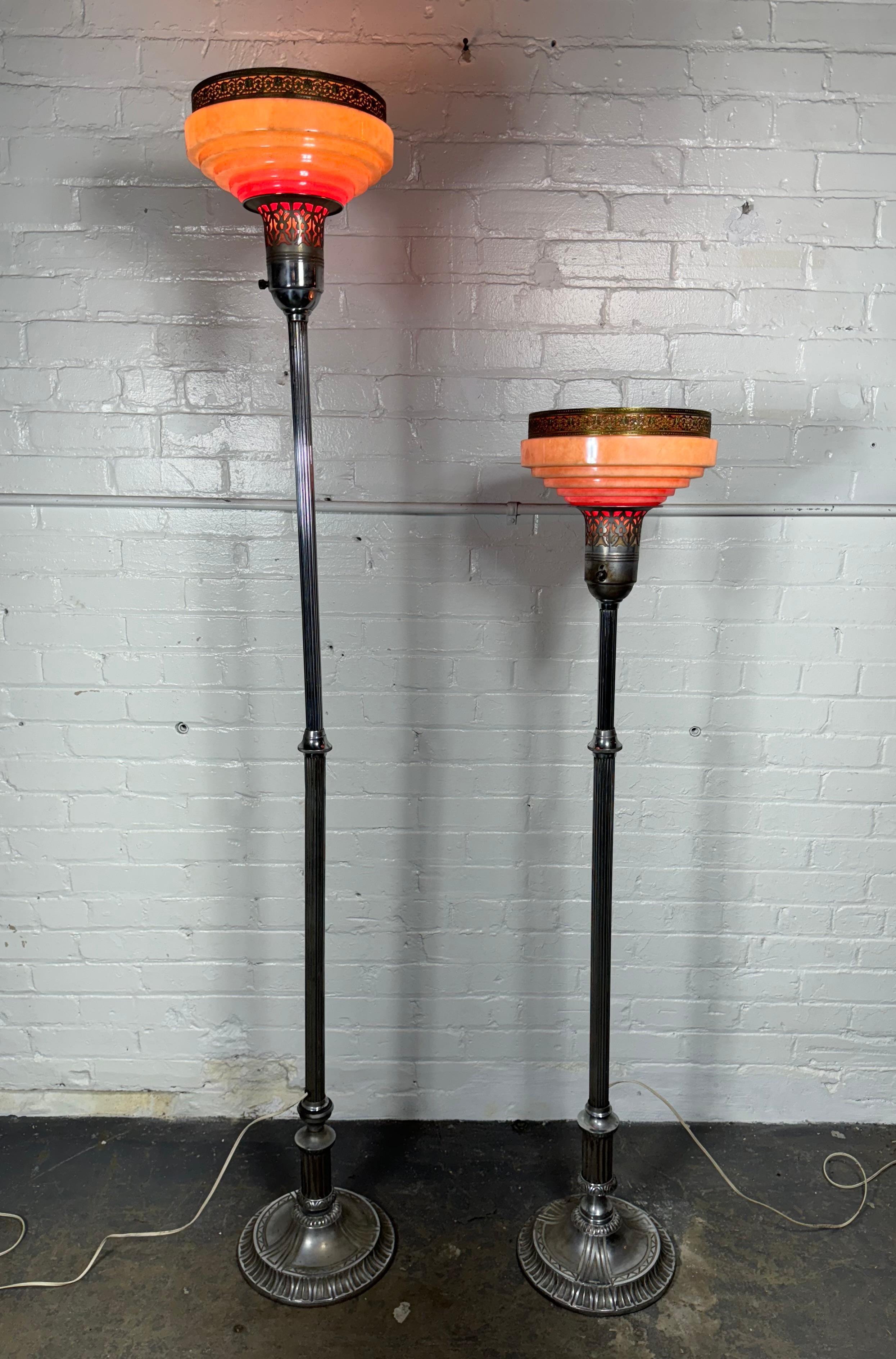Paire de lampes TORCHERE Art dECO en verre et aluminium, réglables en hauteur. Pieds décoratifs en fonte d'aluminium, magnifiques abat-jour en verre à gradins avec détails de bordures en laiton percées. Un abat-jour de lampe endommagé (morceau de