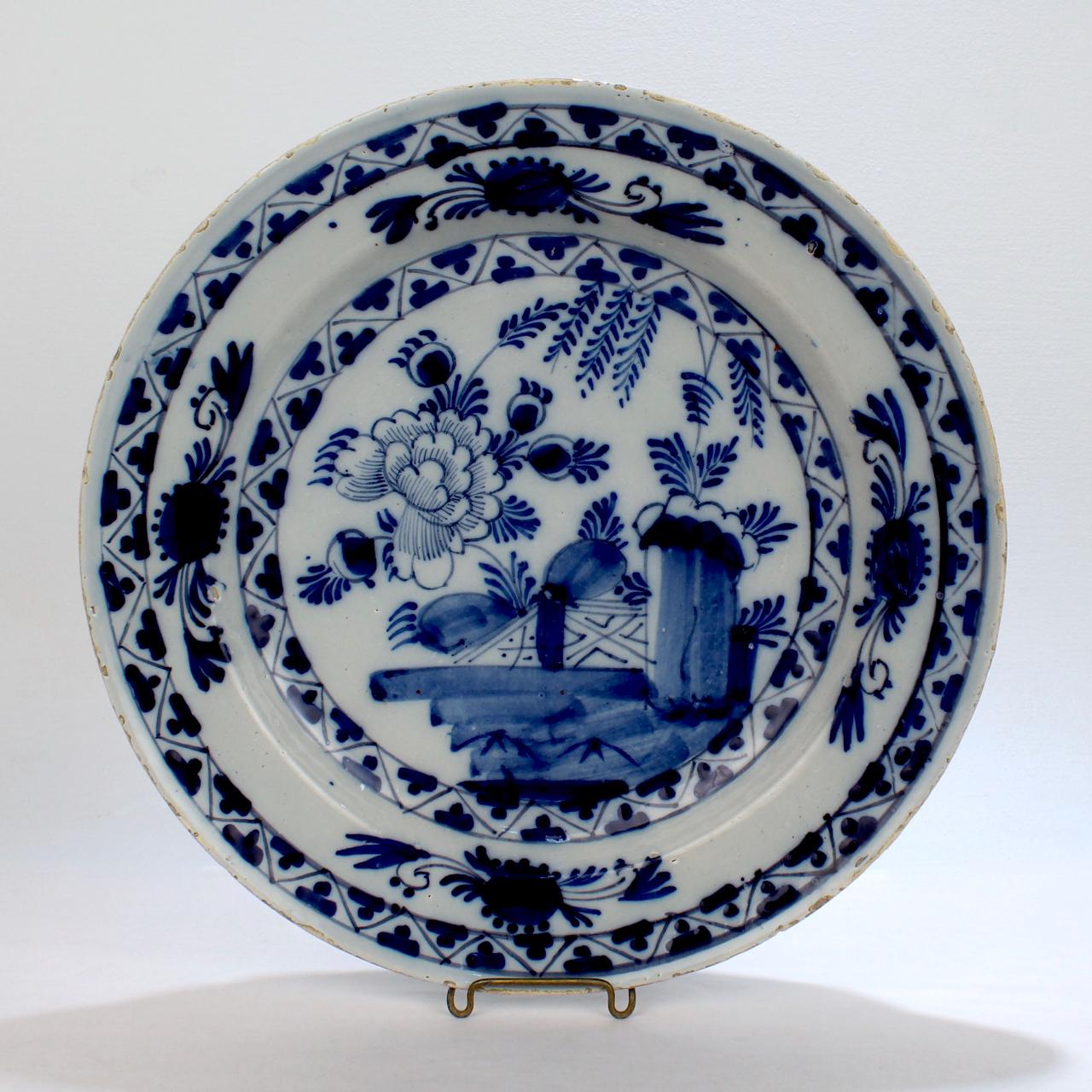 A very fine pair of large, matched Dutch Delft pottery chargers or wall plates.

Dating to the 18th century.

With deep blue Chinoiserie 'Chinese Garden' decoration featuring a large Chrysanthemum blossom.

Measure: Diameter: ca. 13 5/8