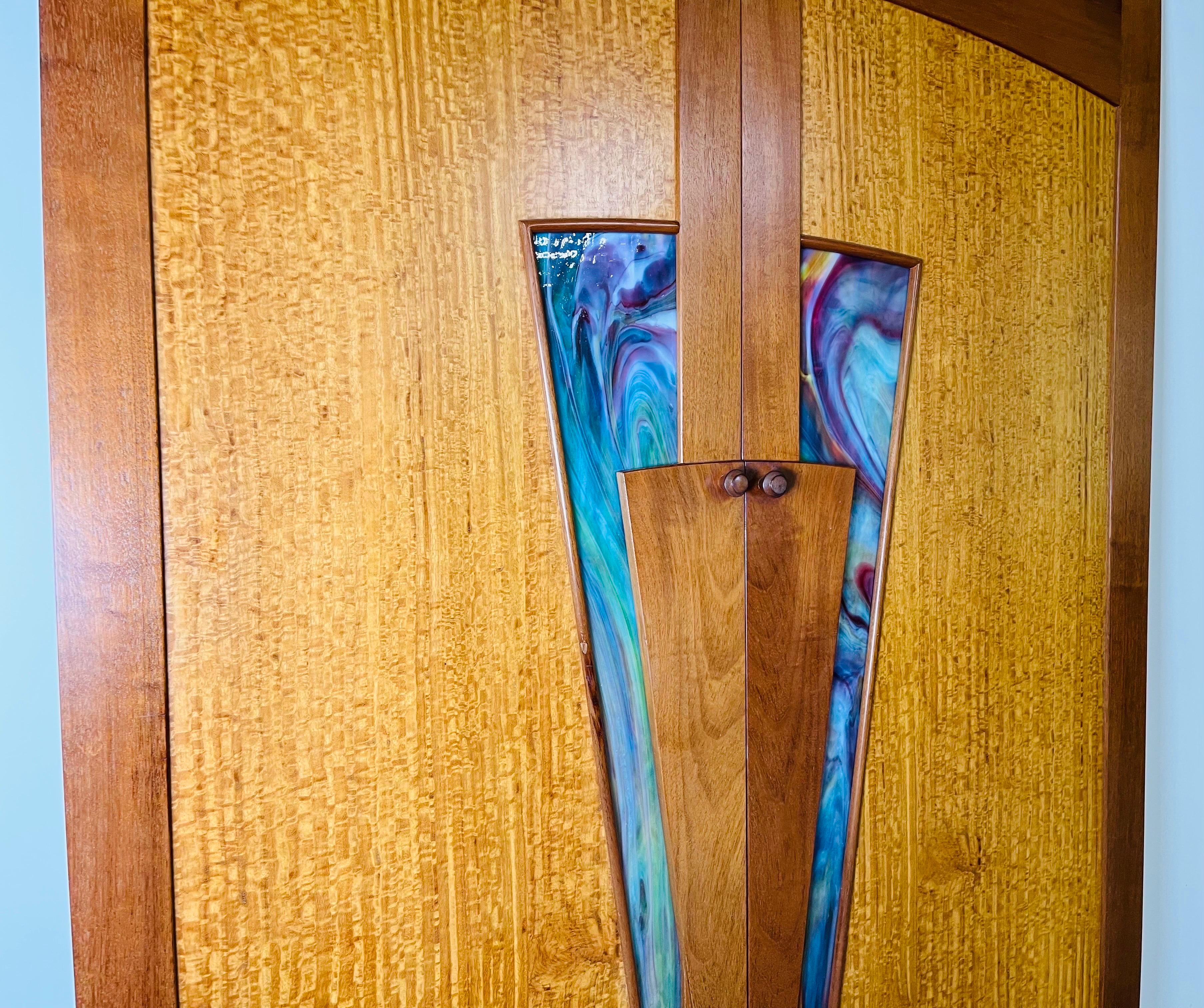 A beautiful pair of apposing custom cabinet doors in the manner of Wharton Esherick having custom stained glass with Cherry, Birdseye Maple and Maple construction. Beautiful carved angles frame the stained glass giving the doors stunning lines. The