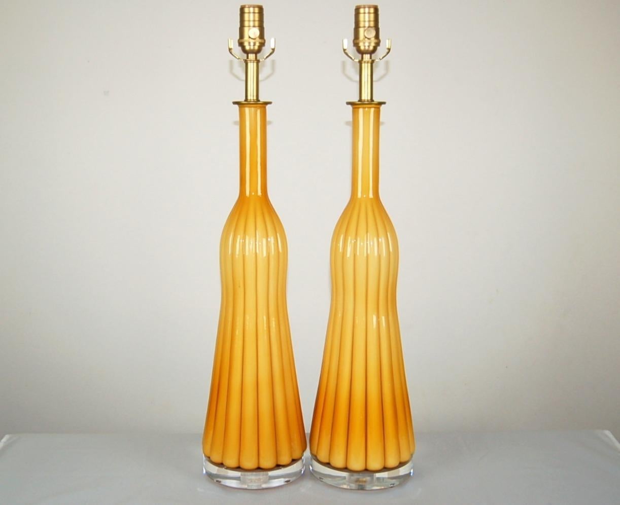 Stilvolle, quastenförmige, RARE Empoli vintage Murano Lampen mit tief ausgeprägten Rippen. Der weiße, ummantelte Glaskern verleiht diesen Lampen eine CREAMY BUTTERSCOTCH gelbe Farbe.

Sie stehen 27 Zoll von der Tischplatte bis zum Sockel. Wie
