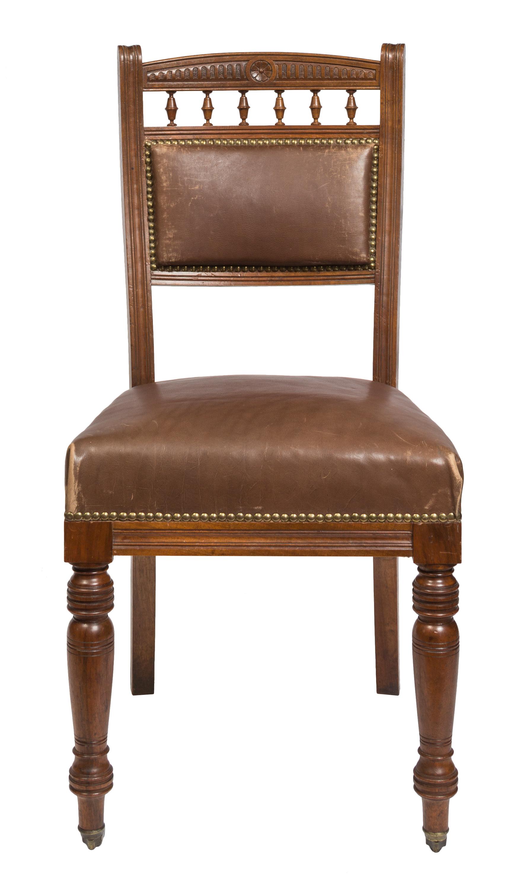A charming pair of Victorian style dining (or boardroom) chairs, upholstered in a milk chocolate brown leather with decorative nail head trim and nicely carved detailing in the chair back. The front legs have casters for ease of movement, and both