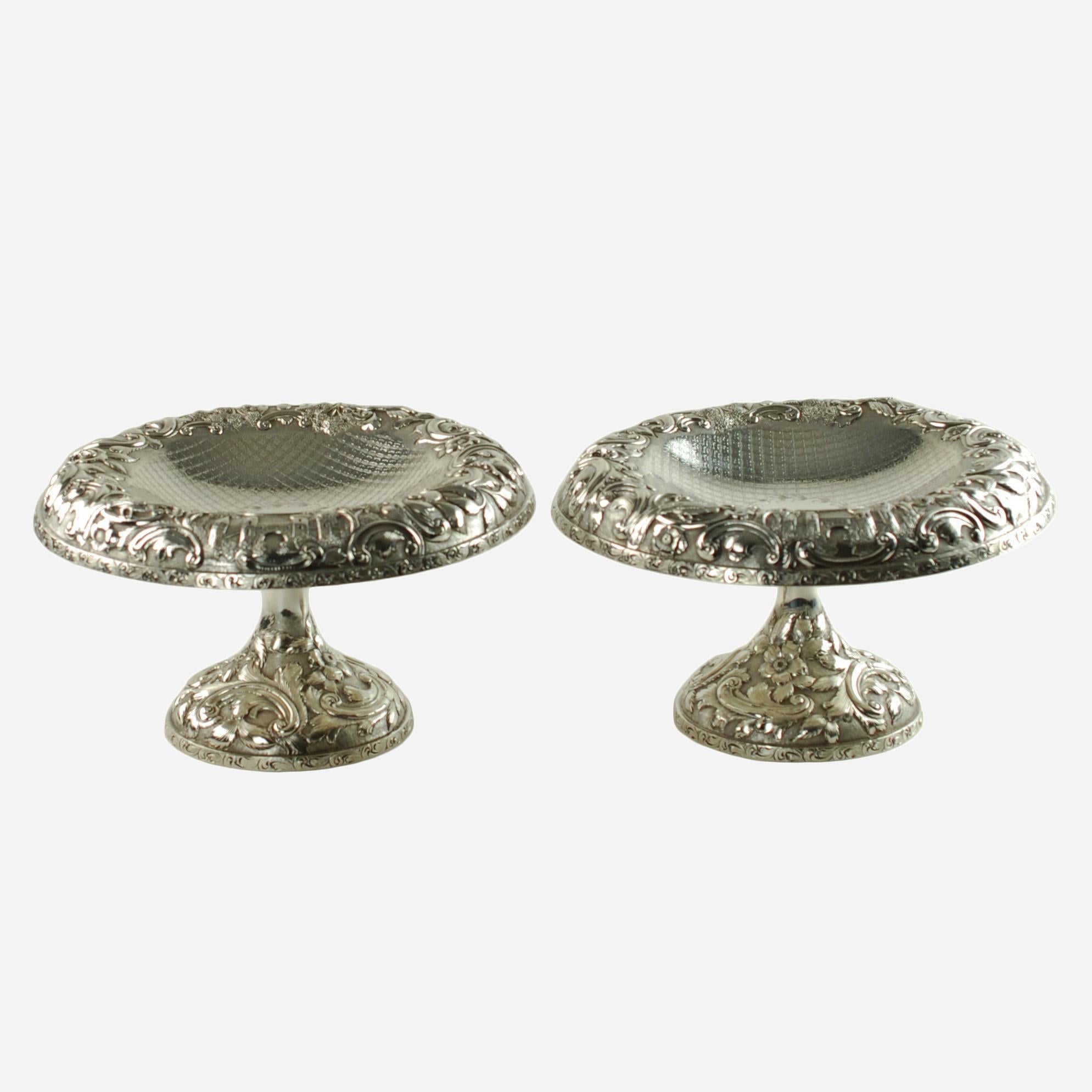 This unusual matched pair of sterling silver tazzas were made by the Baltimore Silversmiths Manufacturing Company, founded in 1903 by Frank M. Schofield. The tazzas have been finished in the elegant Castle Landscape pattern and feature ornate