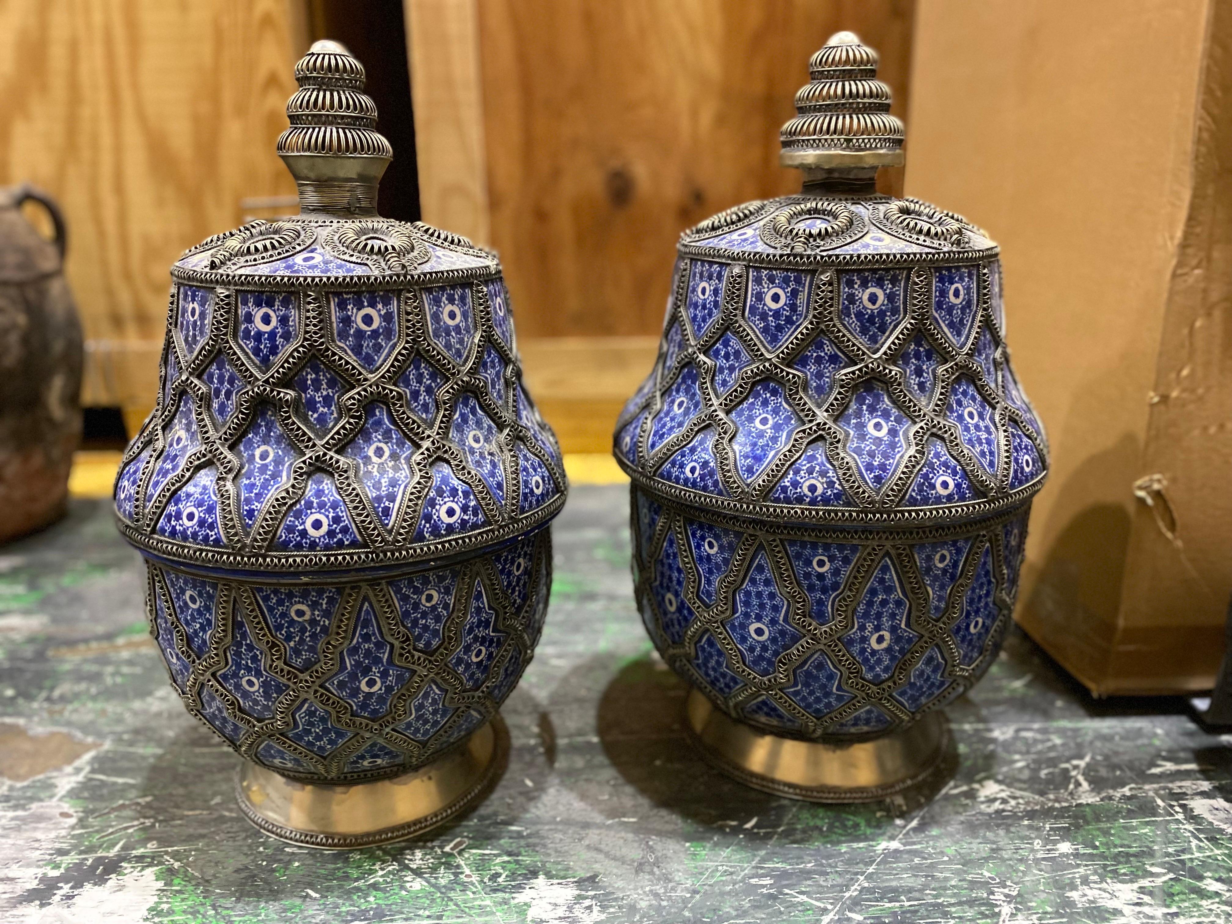 Matched Set of Blue Moroccan Vases with Tops, Late 20th Century
Cobalt on white ground ceramic vases with tops. A unique spiral wire diamond pattern decoration throughout with metal surround base. One very slightly larger than the other. Good