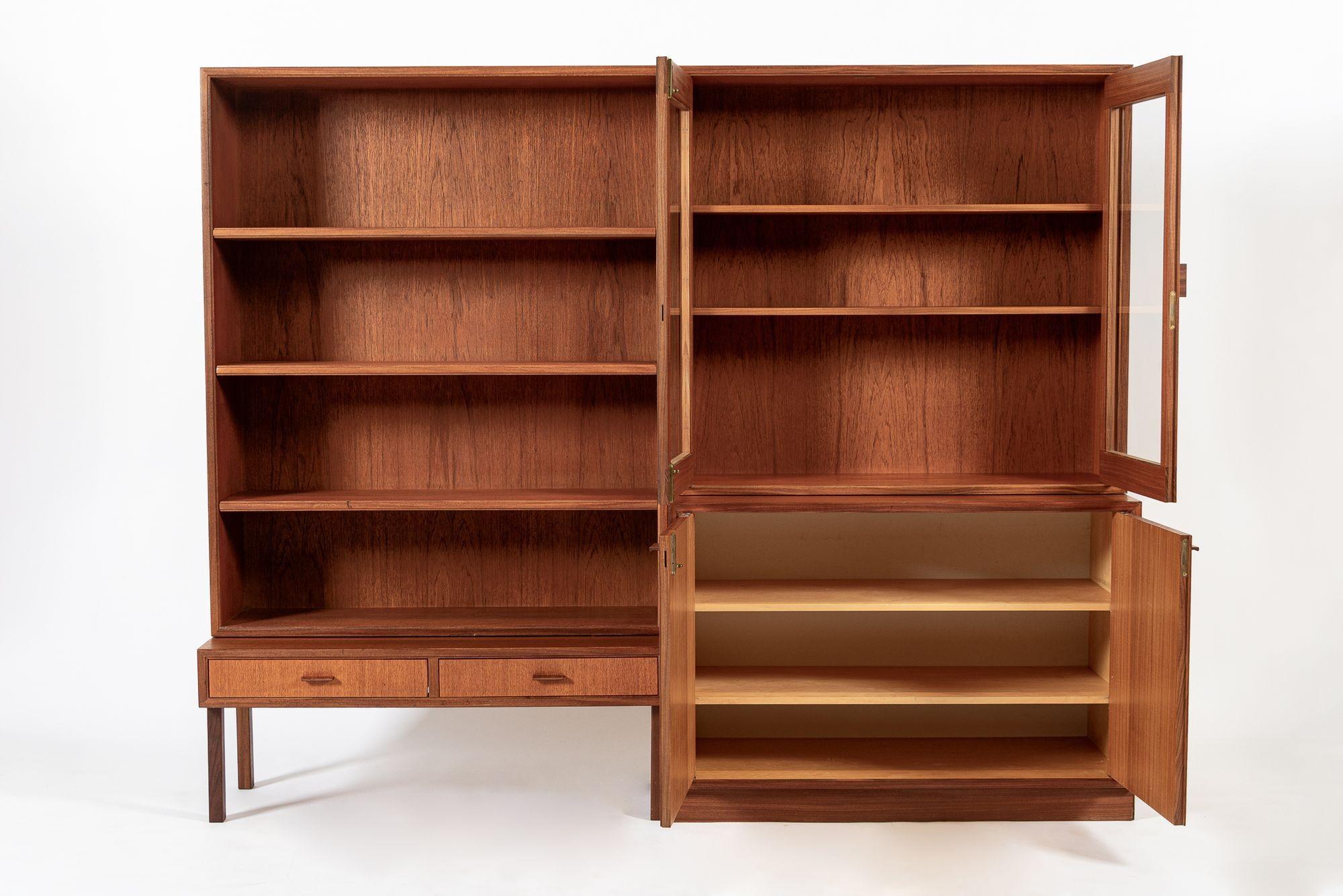 This pair of vintage mid century Swedish modern teak bookshelf cabinets were made in Sweden circa 1960. The two matching cabinets are free-standing and can be used side-by-side as a set or as separate pieces. Each cabinet is also two-piece