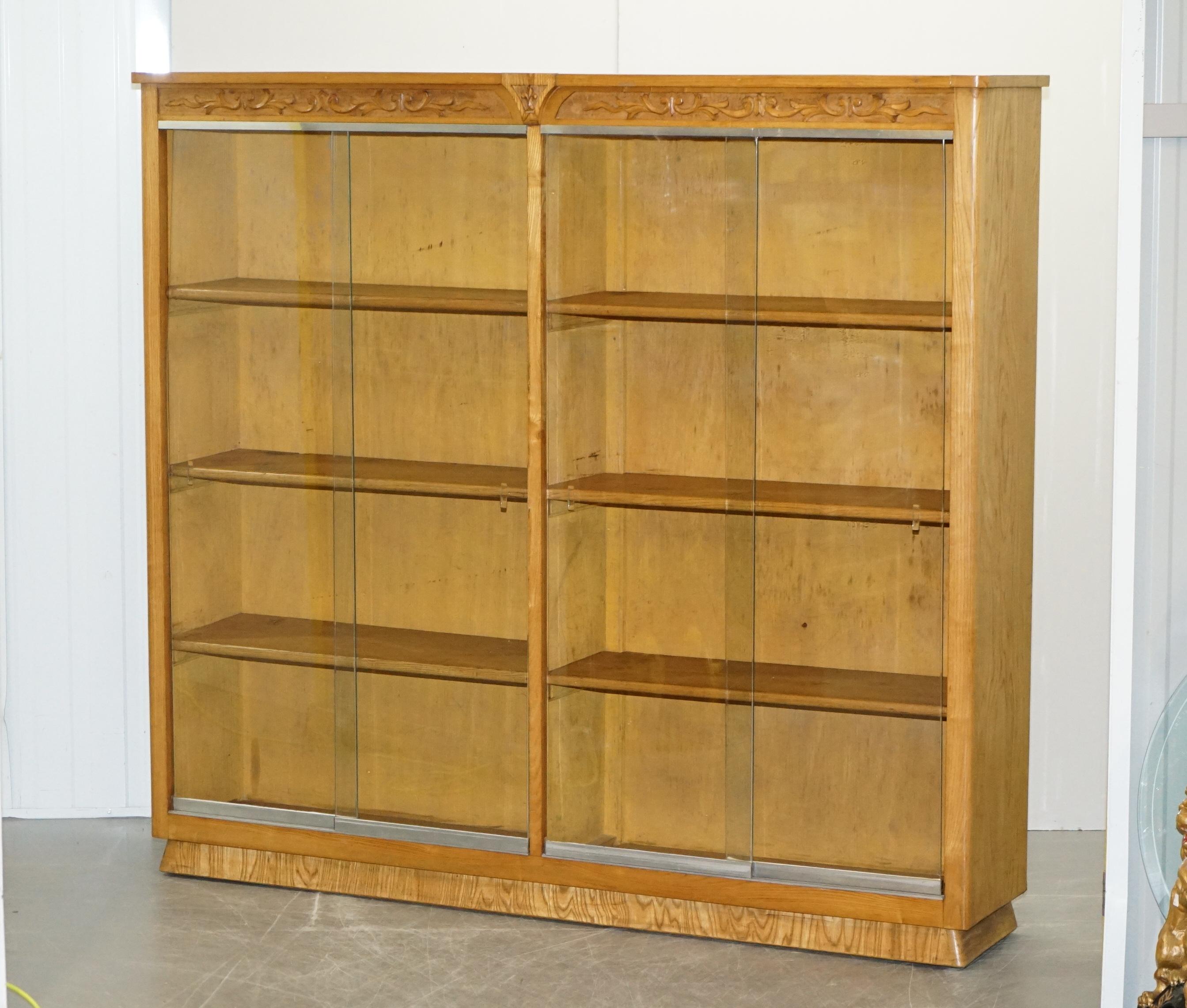 We are is delighted to offer this lovely pair of English circa 1940s oak library legal bookcases with glazed sliding doors and carved tops 

A very large pair, these will easily accommodate and entire families large home library and more. The